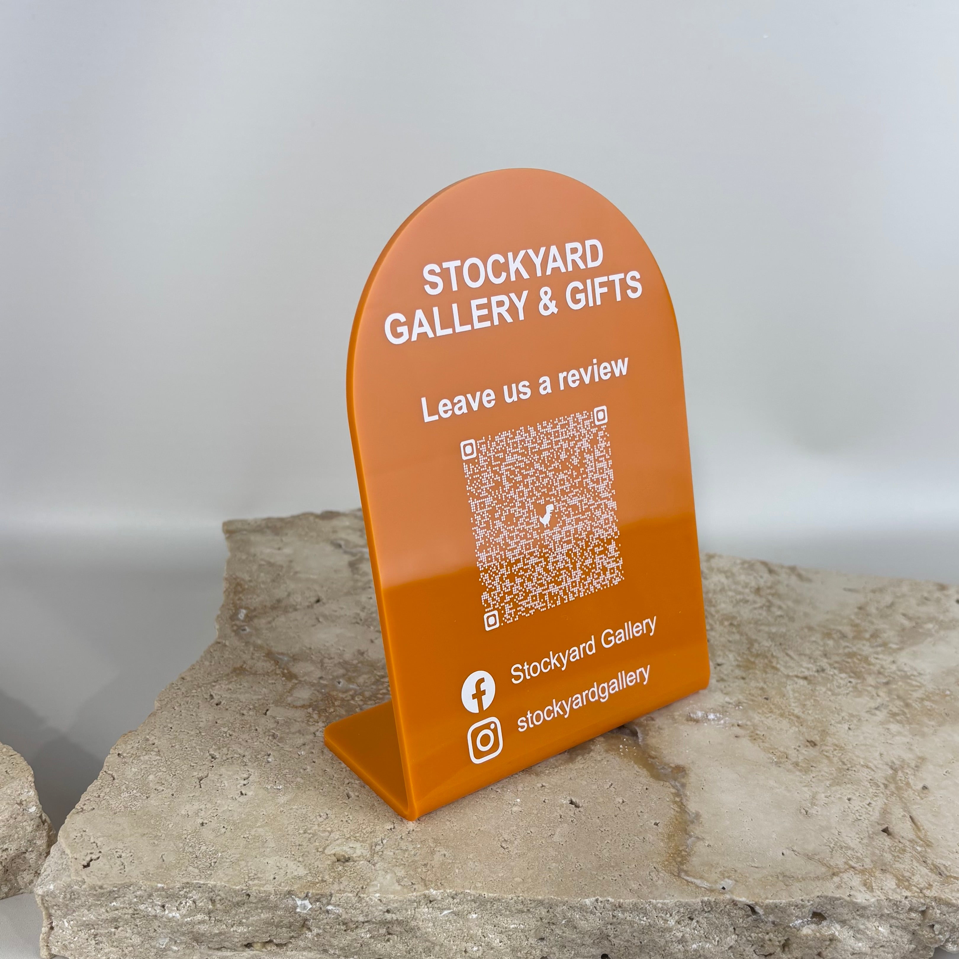 Orange acrylic bend QR code review stand for retail store counters with social media icons and customer feedback display sign for small business marketing.