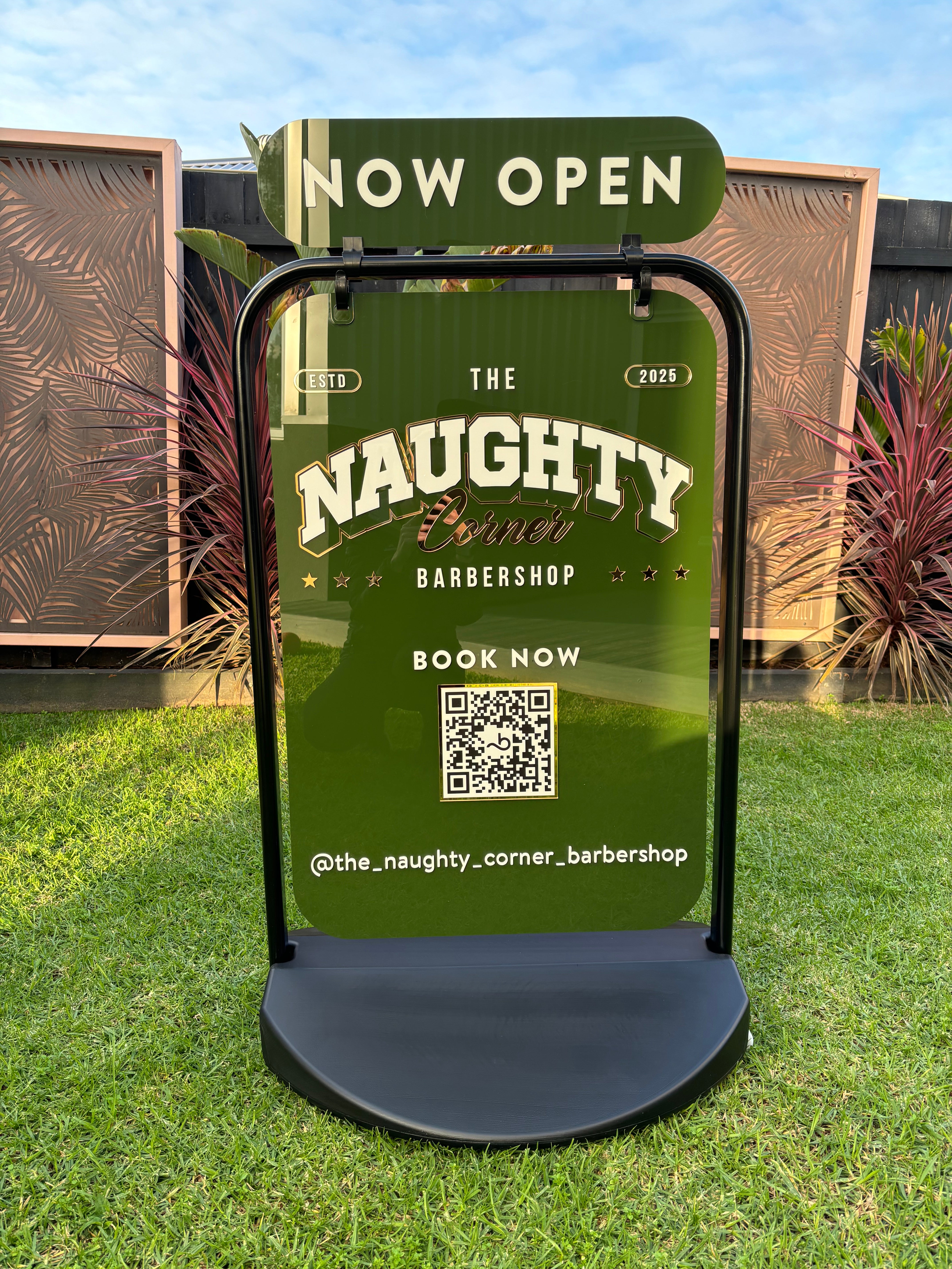Custom green weighted pavement sign promoting barber services