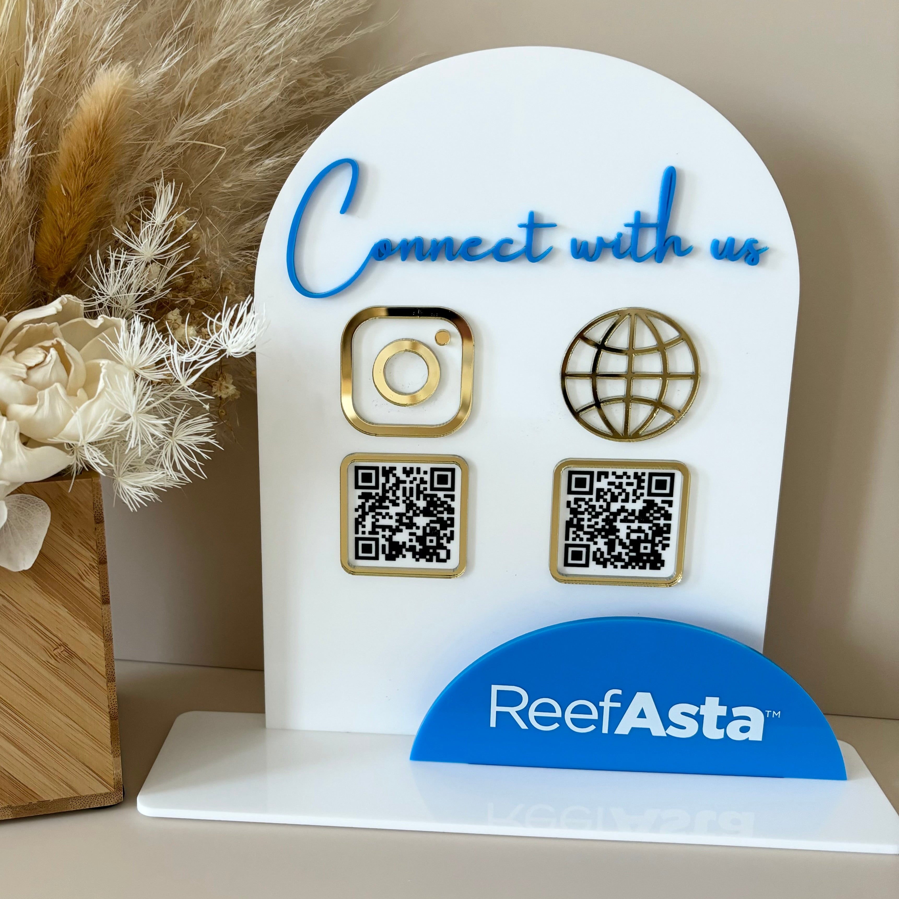 Branded white acrylic business counter display with QR codes and social icons on blue base