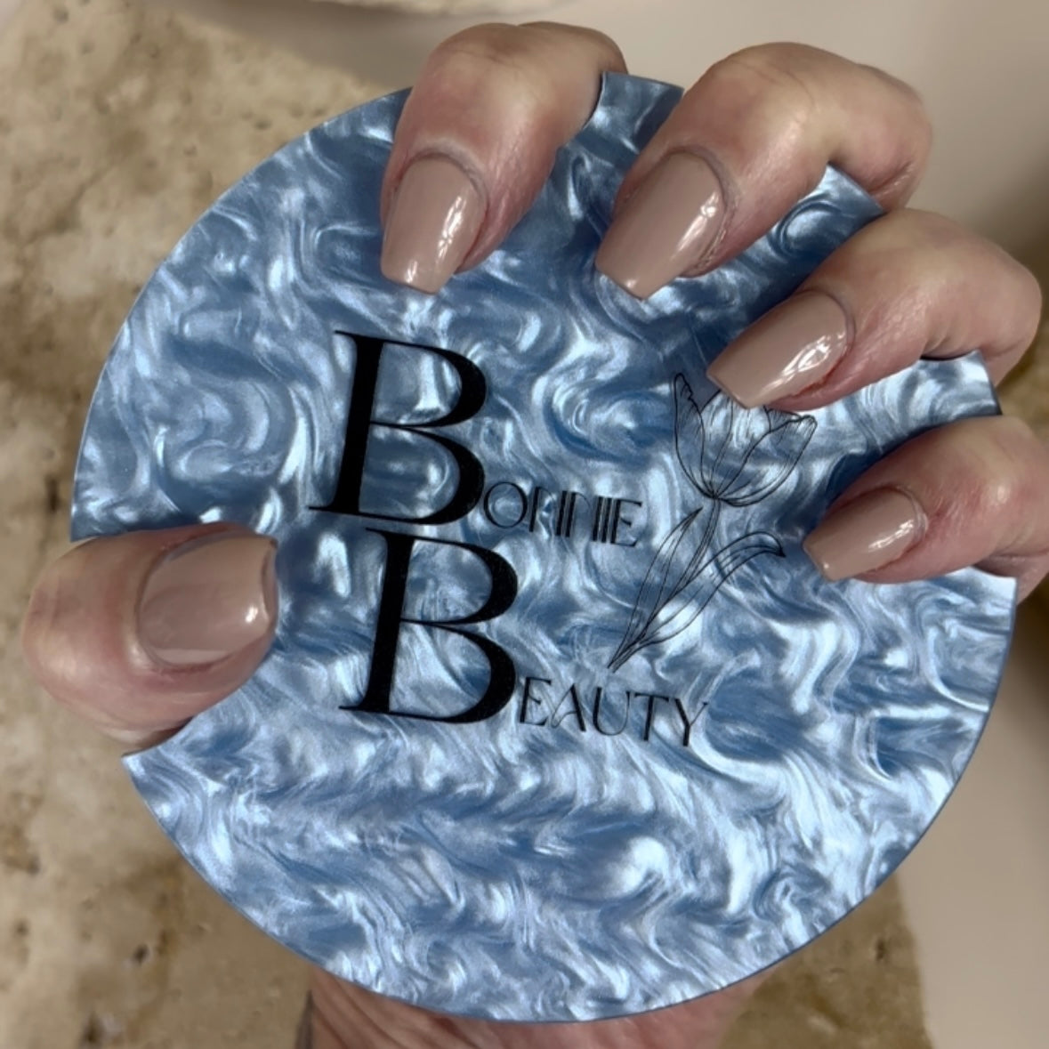 Custom branded nail display prop showing blue acrylic base with salon logo