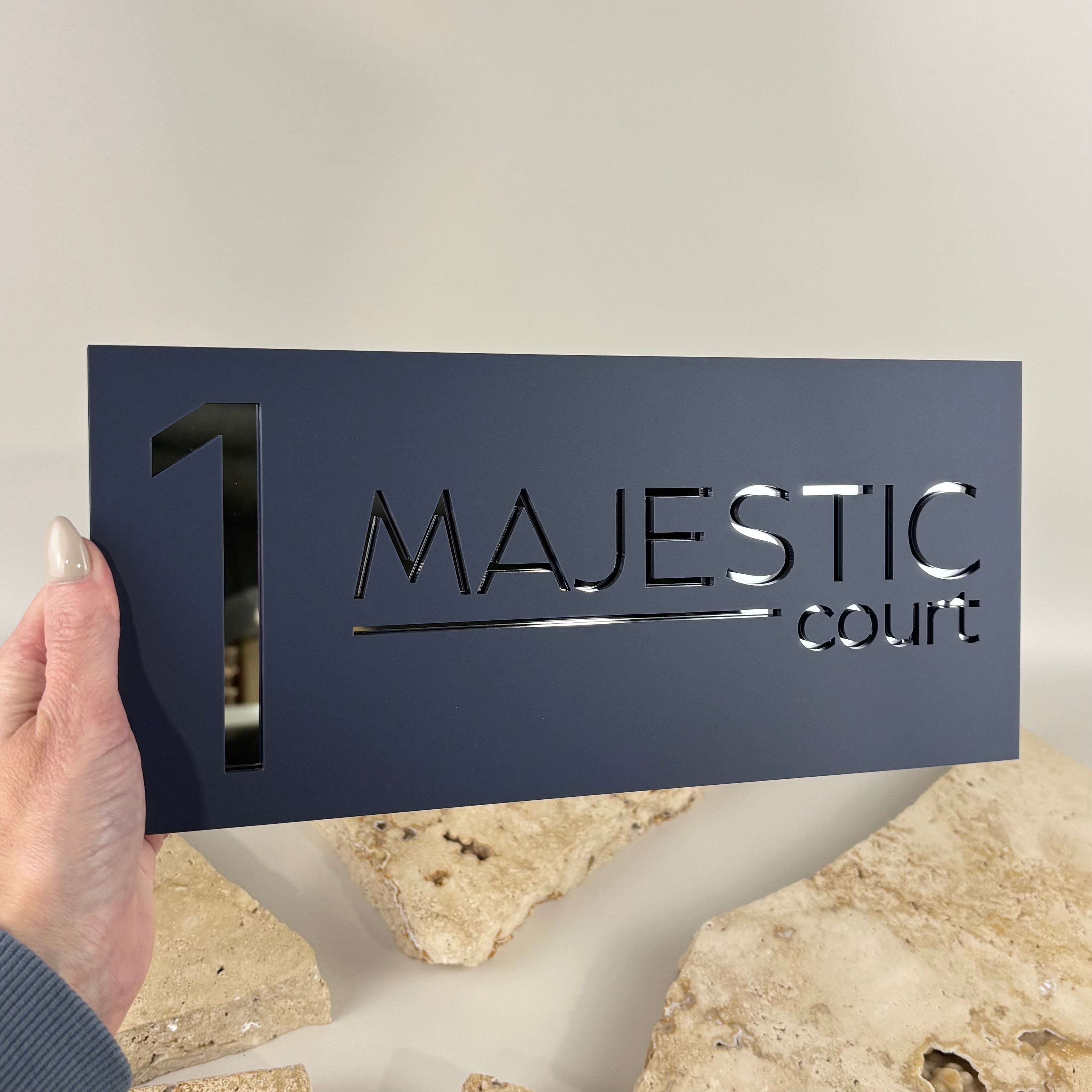 Modern charcoal acrylic house address sign with laser-cut mirrored black acrylic number 1 and Majestic Court street name. Contemporary custom house number plaque designed for exterior home entrances with a sleek minimalist finish.