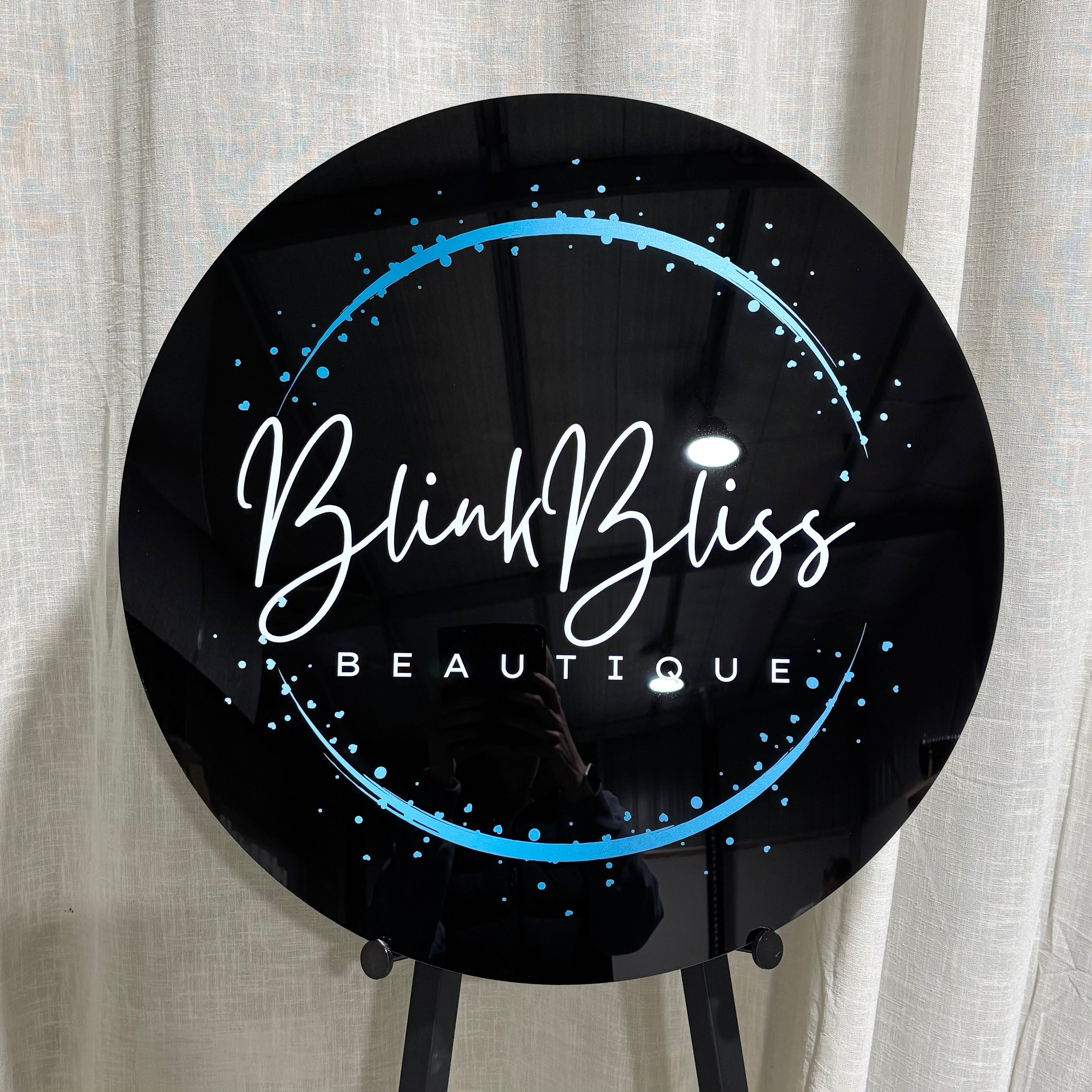 Custom round UV printed acrylic business sign with full colour logo, glossy black finish and personalised branding for beauty salons, lash artists, brow studios, cosmetic clinics, hair salons and small business wall displays