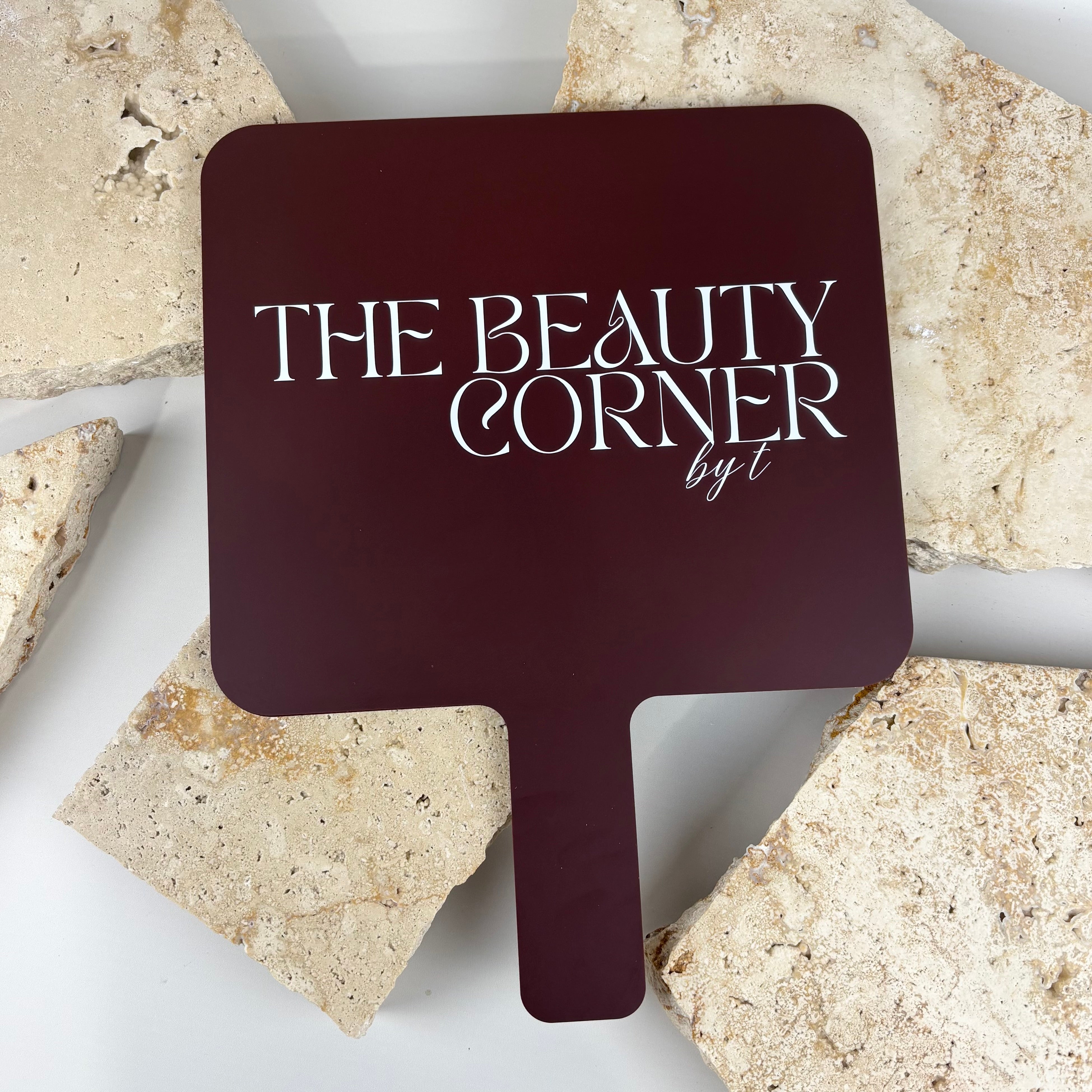 Large branded handheld salon mirror in burgundy acrylic with white logo print, professional hairdressing mirror designed for beauty salons, hair stylists and barbers to show clients the finished hairstyle.