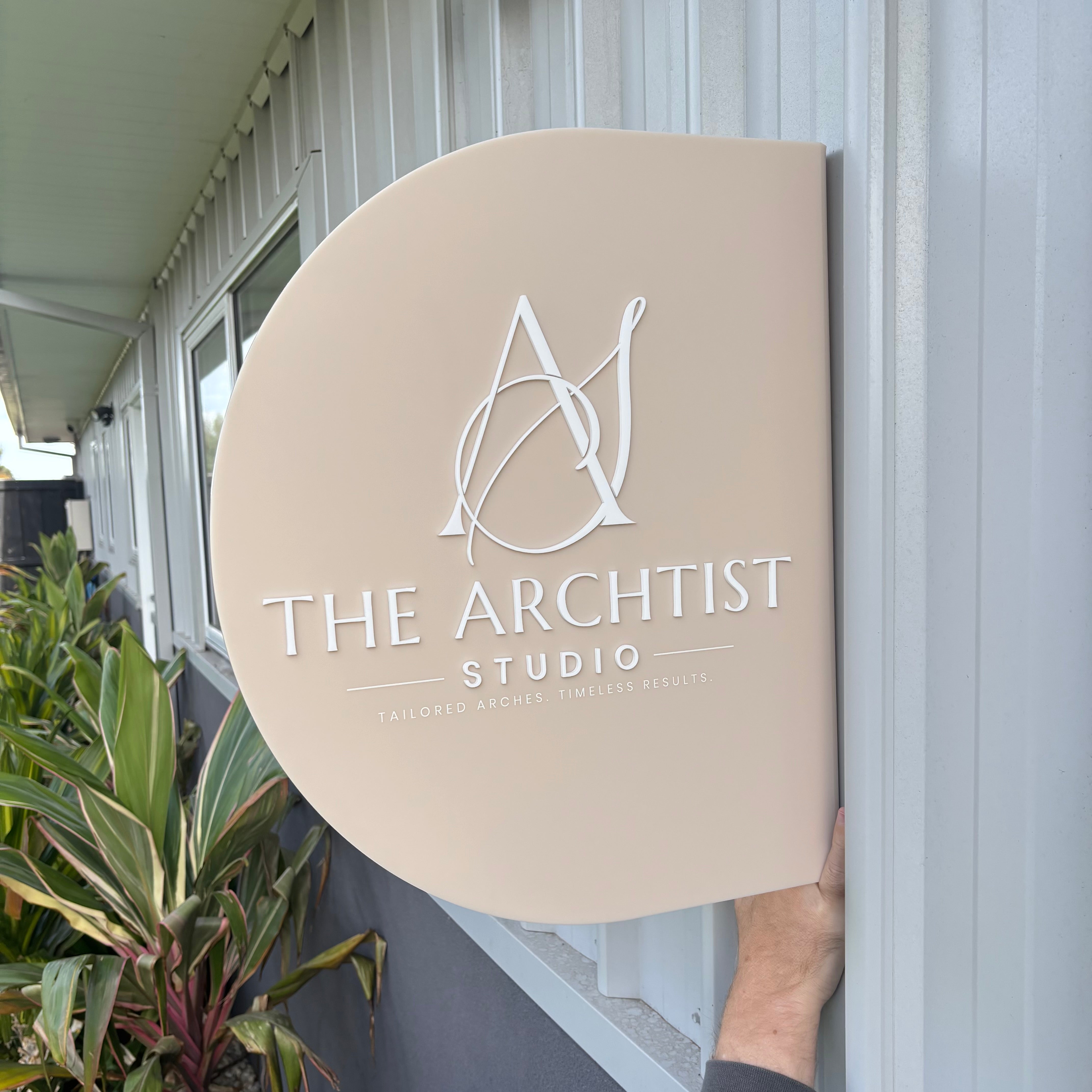 Custom arched acrylic business sign with 3D raised lettering and logo for beauty salons, brow studios and cosmetic businesses. Premium outdoor business signage featuring layered acrylic lettering, modern neutral tones and professional storefront branding.