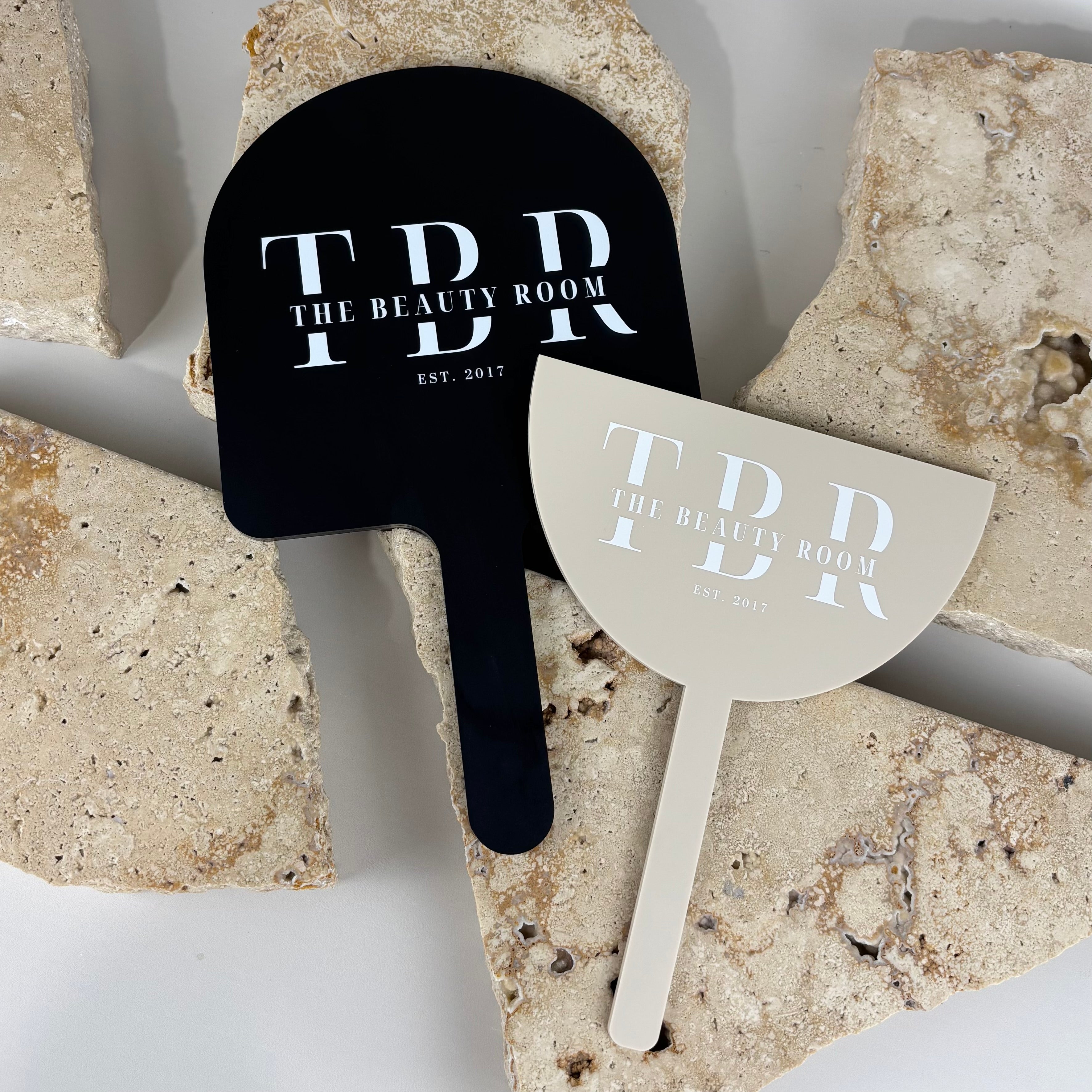 Custom acrylic handheld salon mirrors in black and beige, branded with The Beauty Room logo, lightweight professional beauty mirror designed for hair and beauty salons