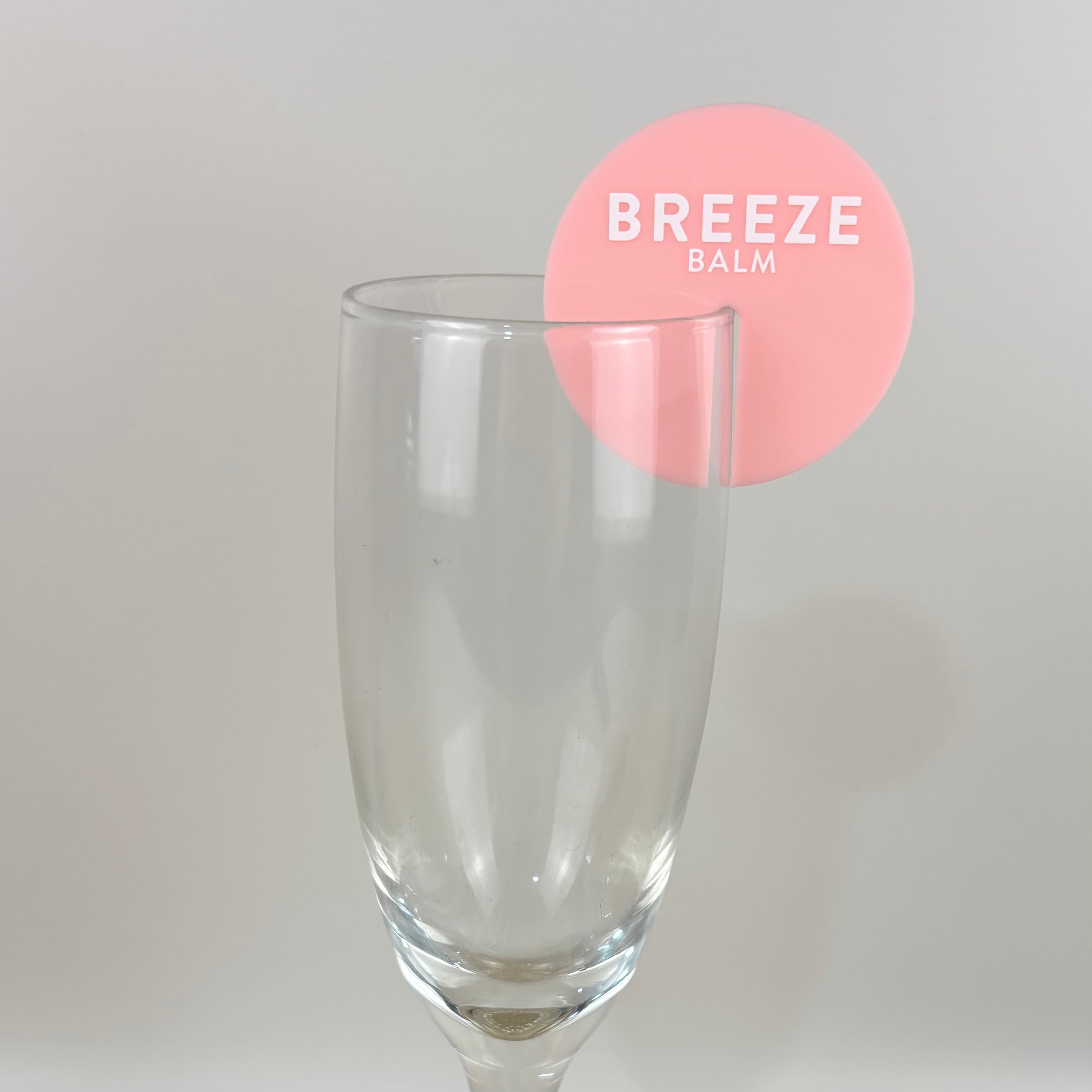 Custom acrylic drink stirrer in soft pink with Breeze Balm branding, round cocktail stirrer designed for brand events, product launches and promotional drink styling.