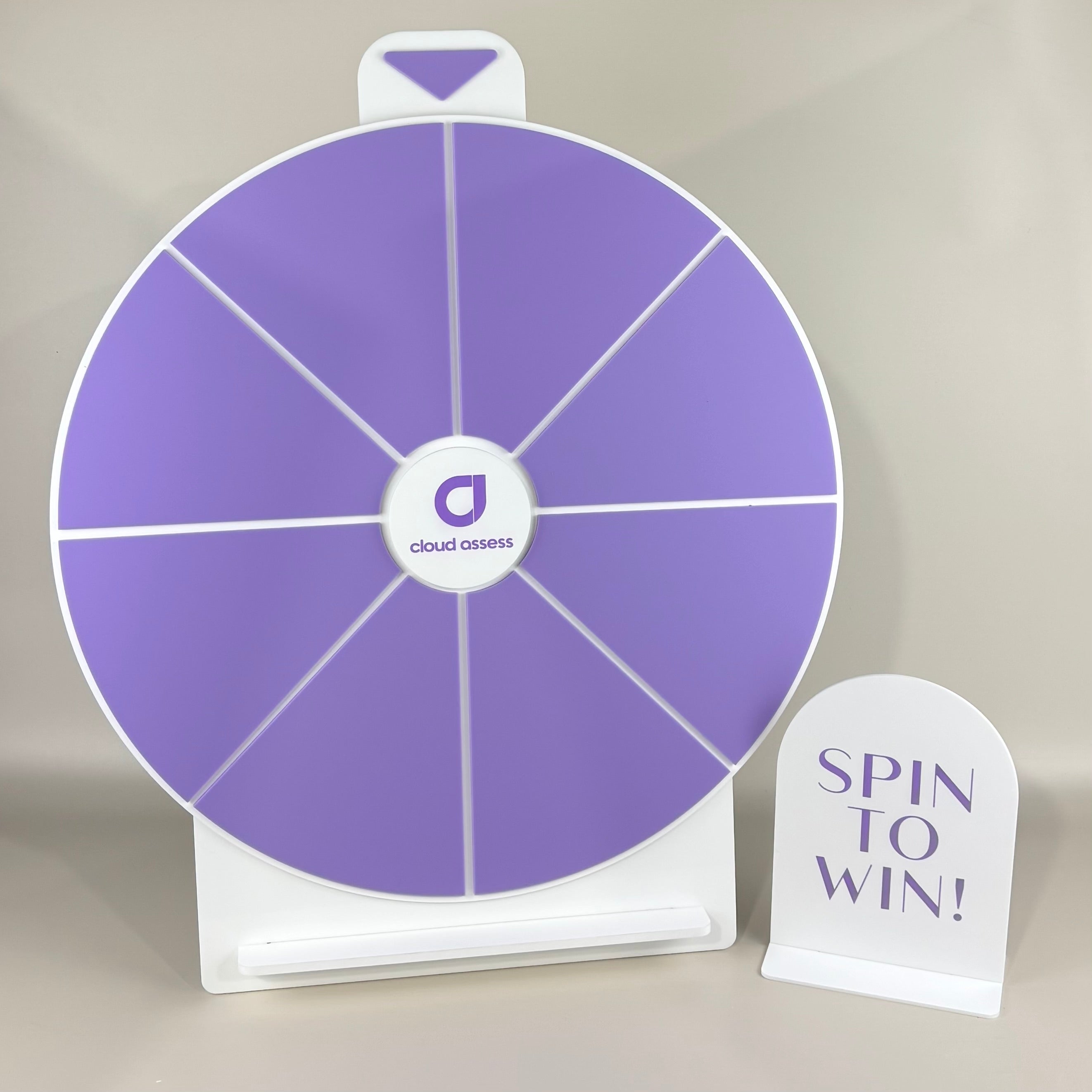 Custom branded spin the wheel game for Cloud Assess in lilac and white featuring company logo, prize sections, and matching ‘Spin to Win!’ display sign – promotional event signage made in Australia by Laser Edge Designs.