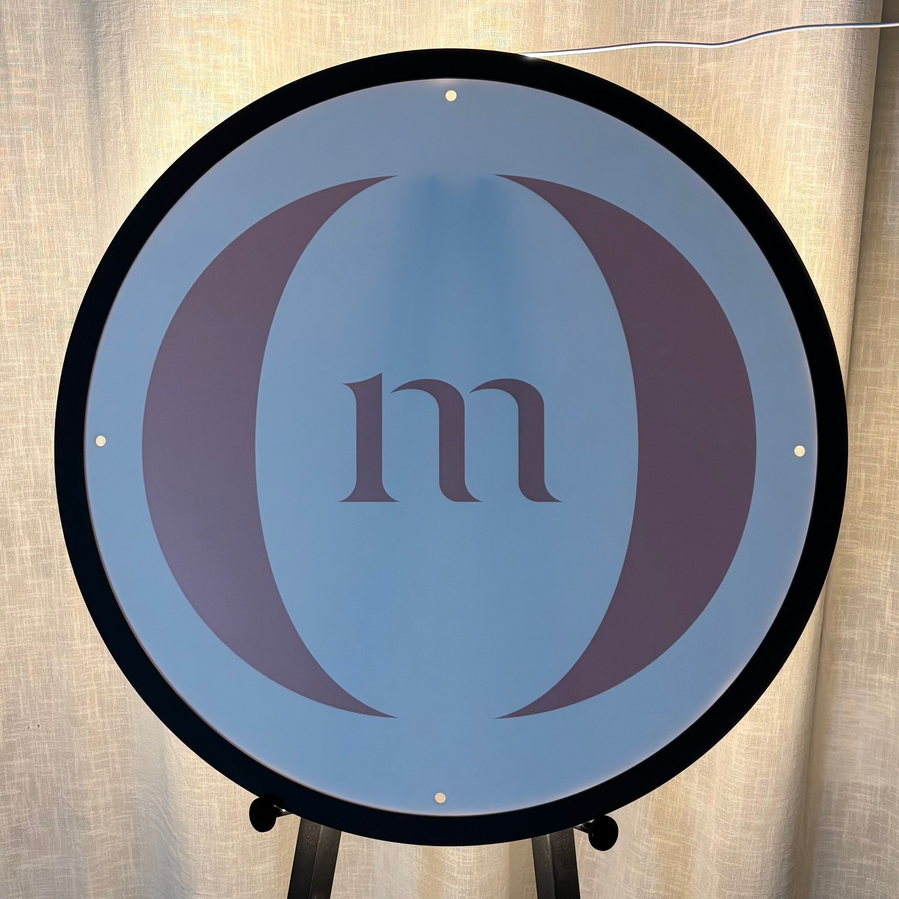 Custom backlit round acrylic business sign with UV printed monogram logo, warm white LED halo lighting and premium acrylic construction, ideal for beauty salons, cosmetic clinics, retail stores and professional business branding.