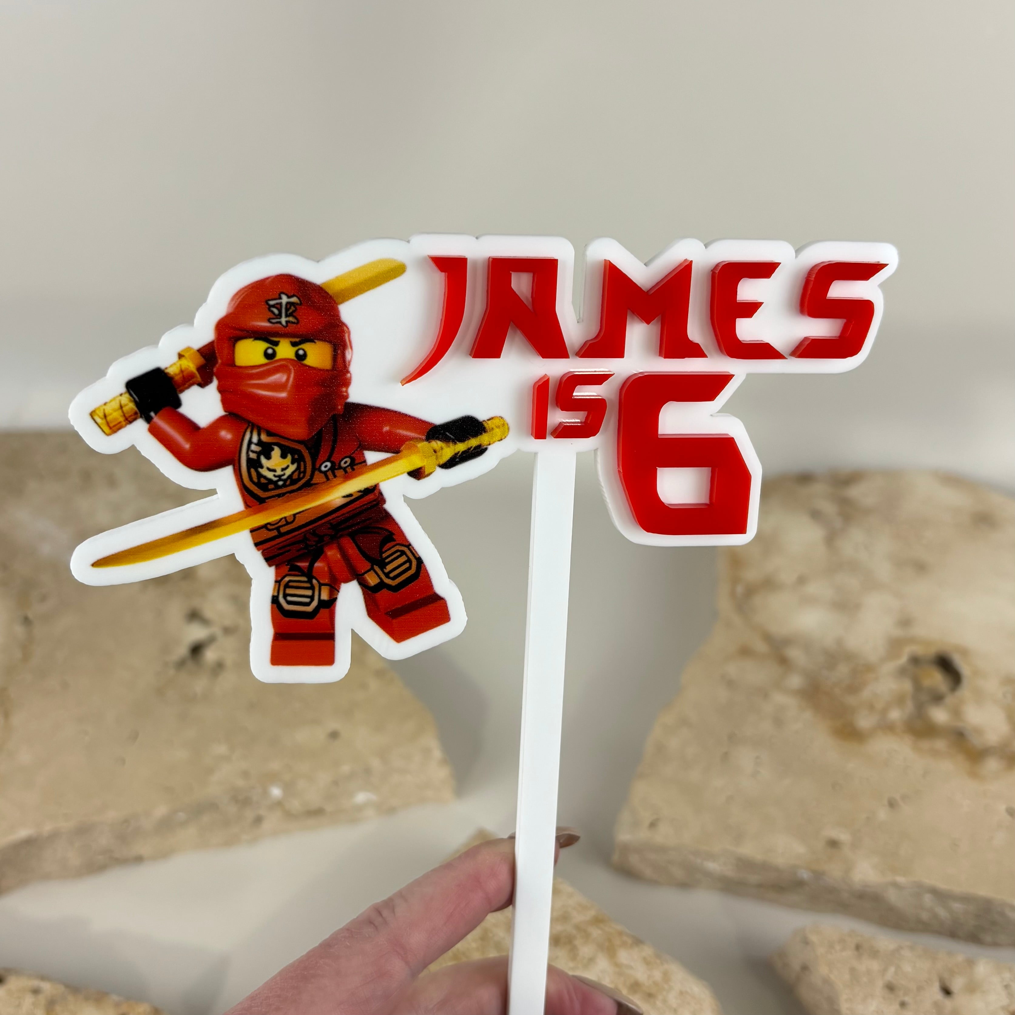 Custom 3D and UV printed acrylic cake topper featuring personalised name and age design with layered raised lettering and vibrant ninja inspired character artwork. Premium birthday cake topper made from durable acrylic, perfect for kids birthday parties, themed celebrations and custom event styling in Australia.