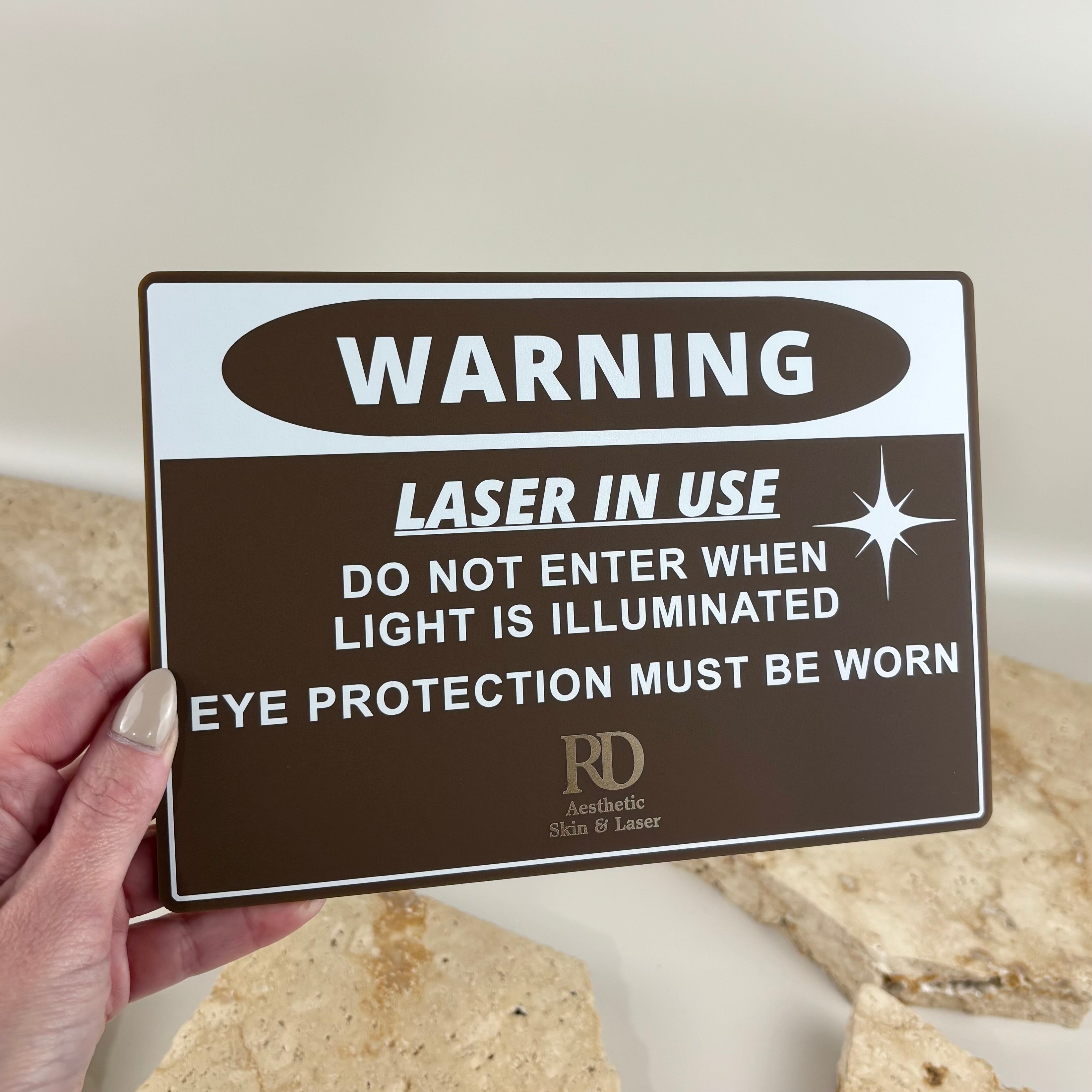 Custom black metal A-frame pavement sign with white acrylic panel and gold mirror 3D lettering for RD Aesthetic Skin & Laser clinic.