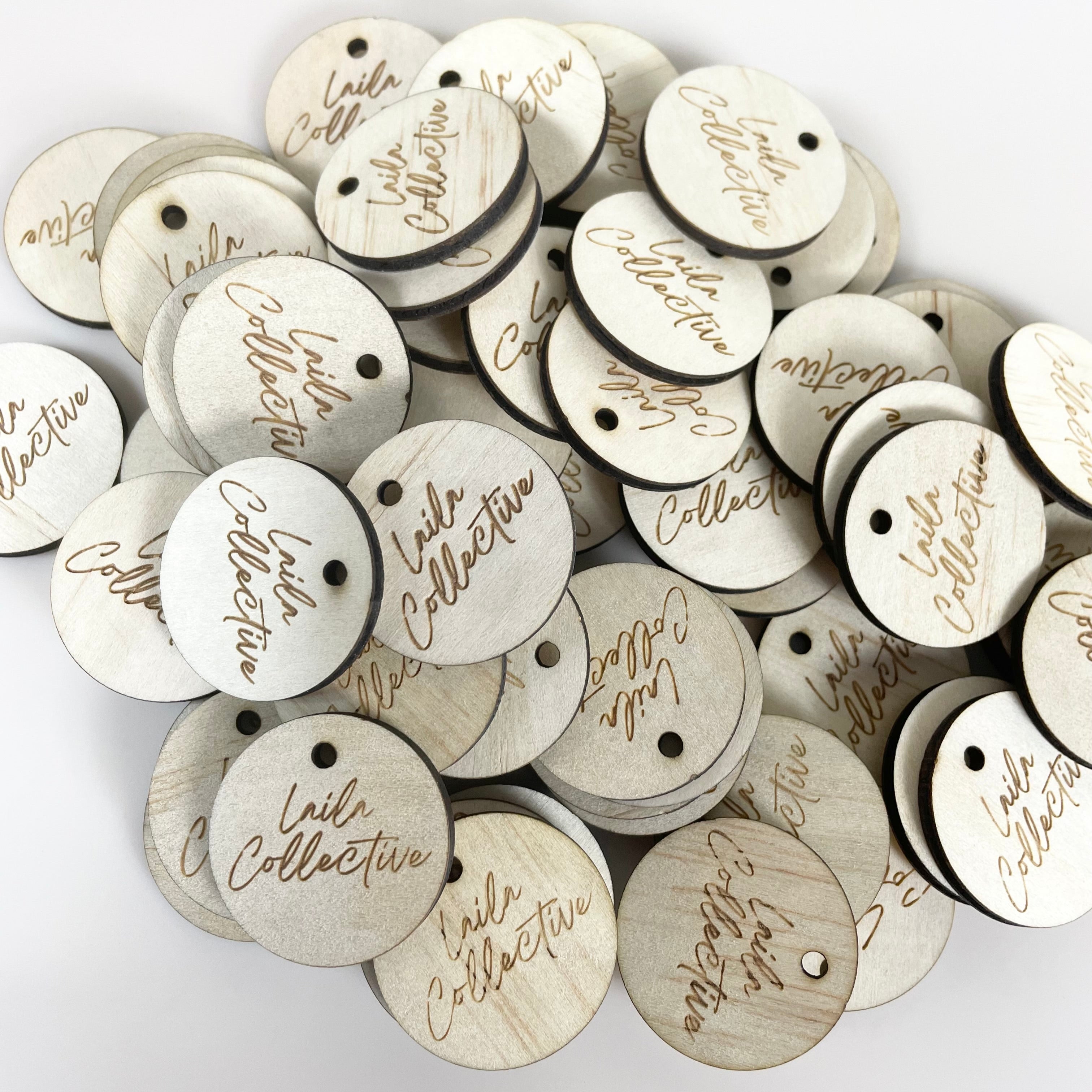 Pile of small engraved wooden tags with business names for handmade items