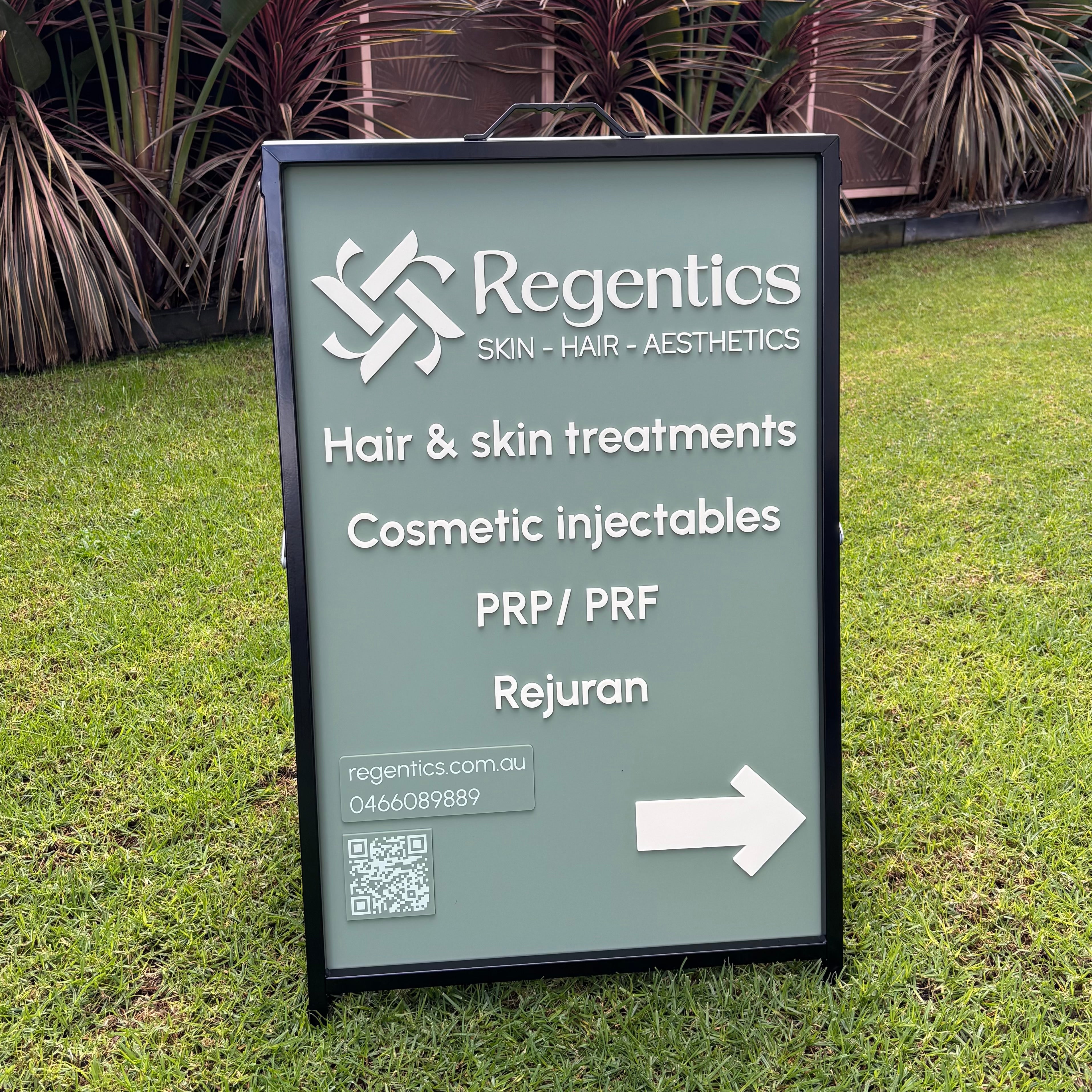 Outdoor A-frame pavement sign for Regentics featuring sage green acrylic with white 3D acrylic lettering, QR code and directional arrow, promoting skin, hair and aesthetic treatments including cosmetic injectables, PRP, PRF and Rejuran.