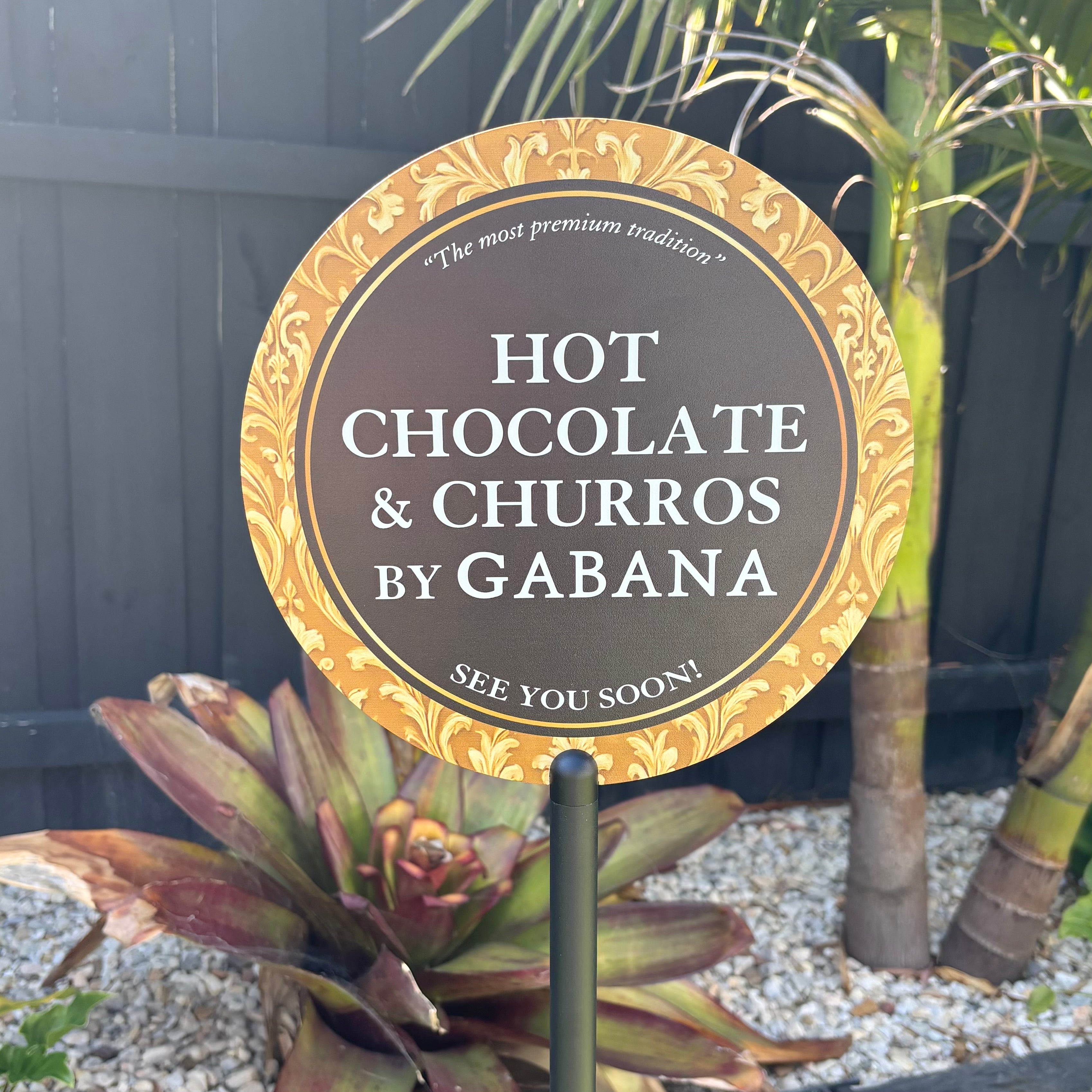 Round metal floor stand sign displaying “Hot Chocolate & Churros” branding, ideal for cafés, food stalls, events, and outdoor hospitality signage.