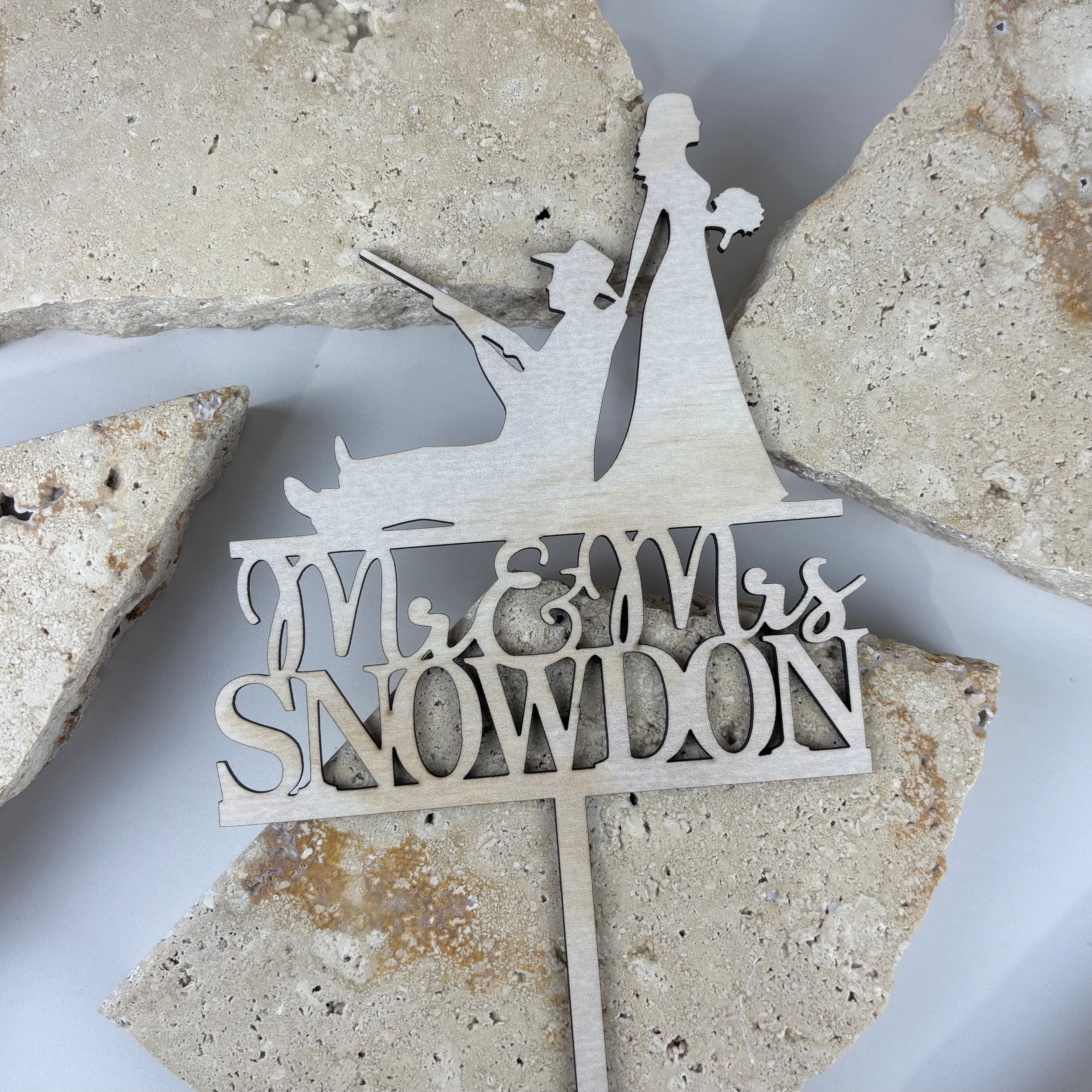 Laser cut timber cake topper featuring “Mr & Mrs Snowdon” with bride and groom silhouette, personalised wooden wedding cake topper designed for wedding cakes, engagement parties and bridal celebrations.