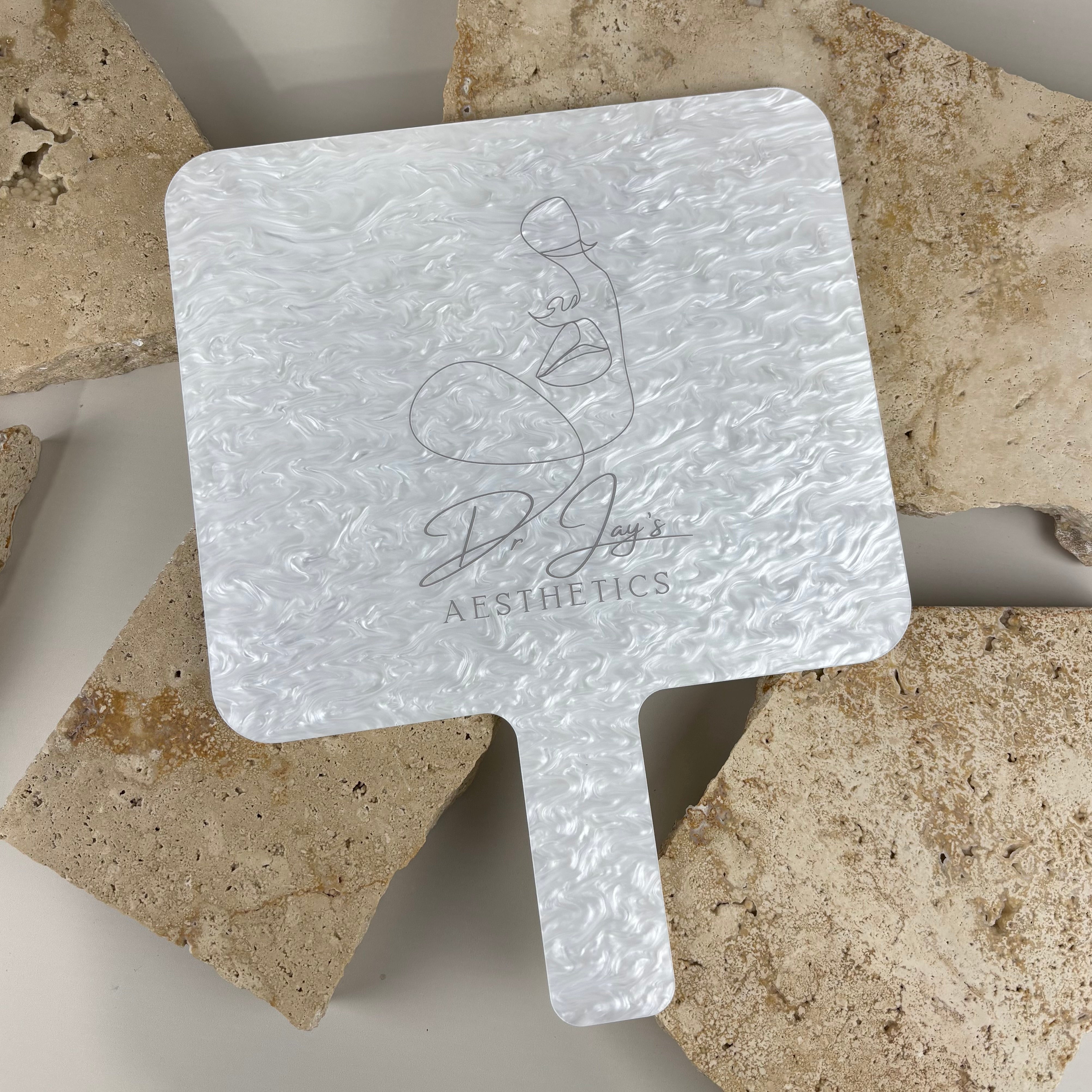 Large pearlescent acrylic handheld salon mirror with engraved logo, luxury hairdressing mirror designed for beauty salons, aesthetic clinics and hairstylists to showcase completed hair and beauty treatments.