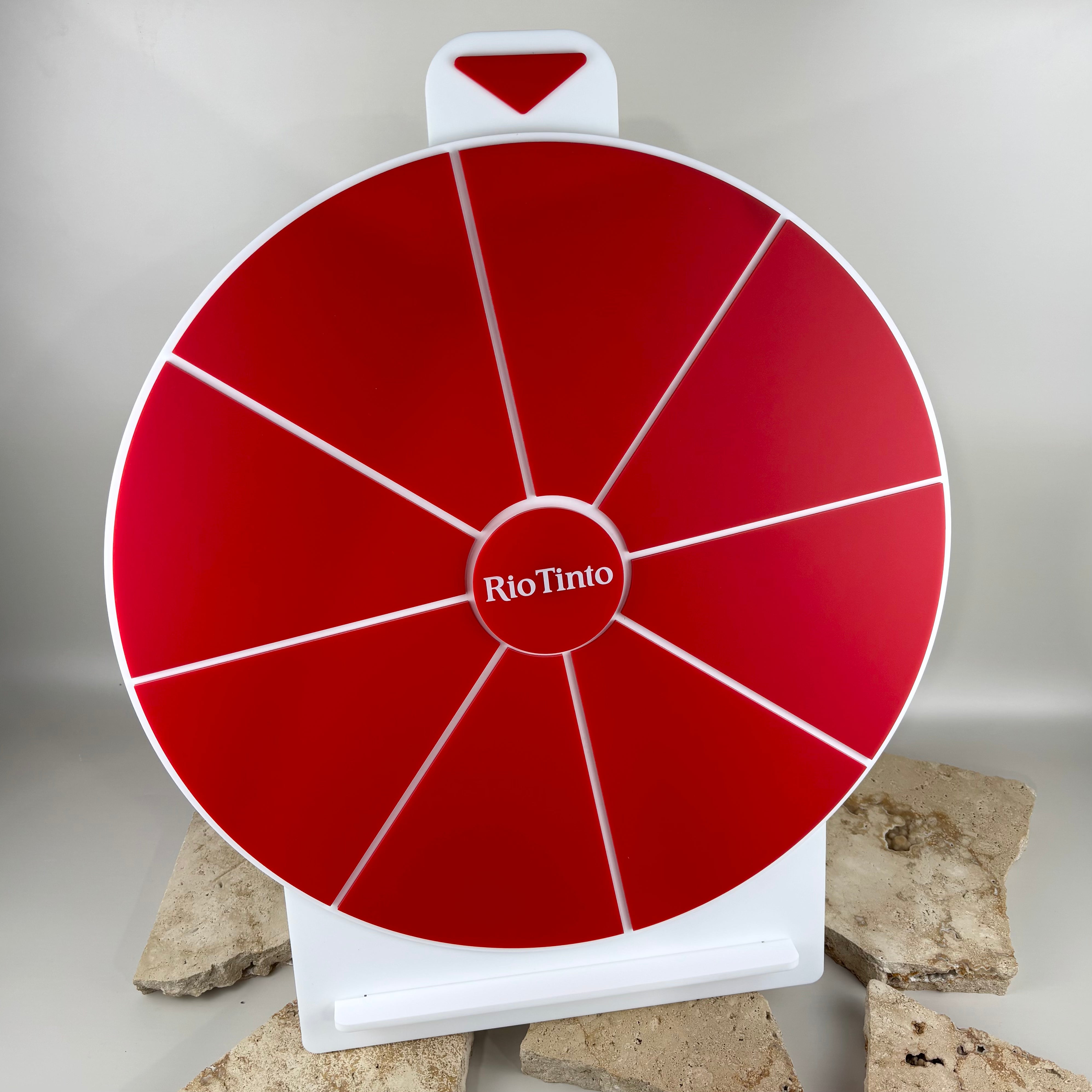 Custom red and white acrylic spin to win prize wheel with branded Rio Tinto centre logo, designed for business promotions, corporate events, giveaways and interactive displays