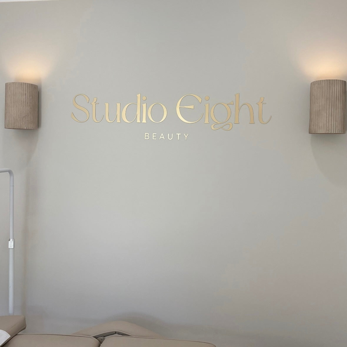 Custom gold acrylic wall lettering sign for beauty salon reception area
