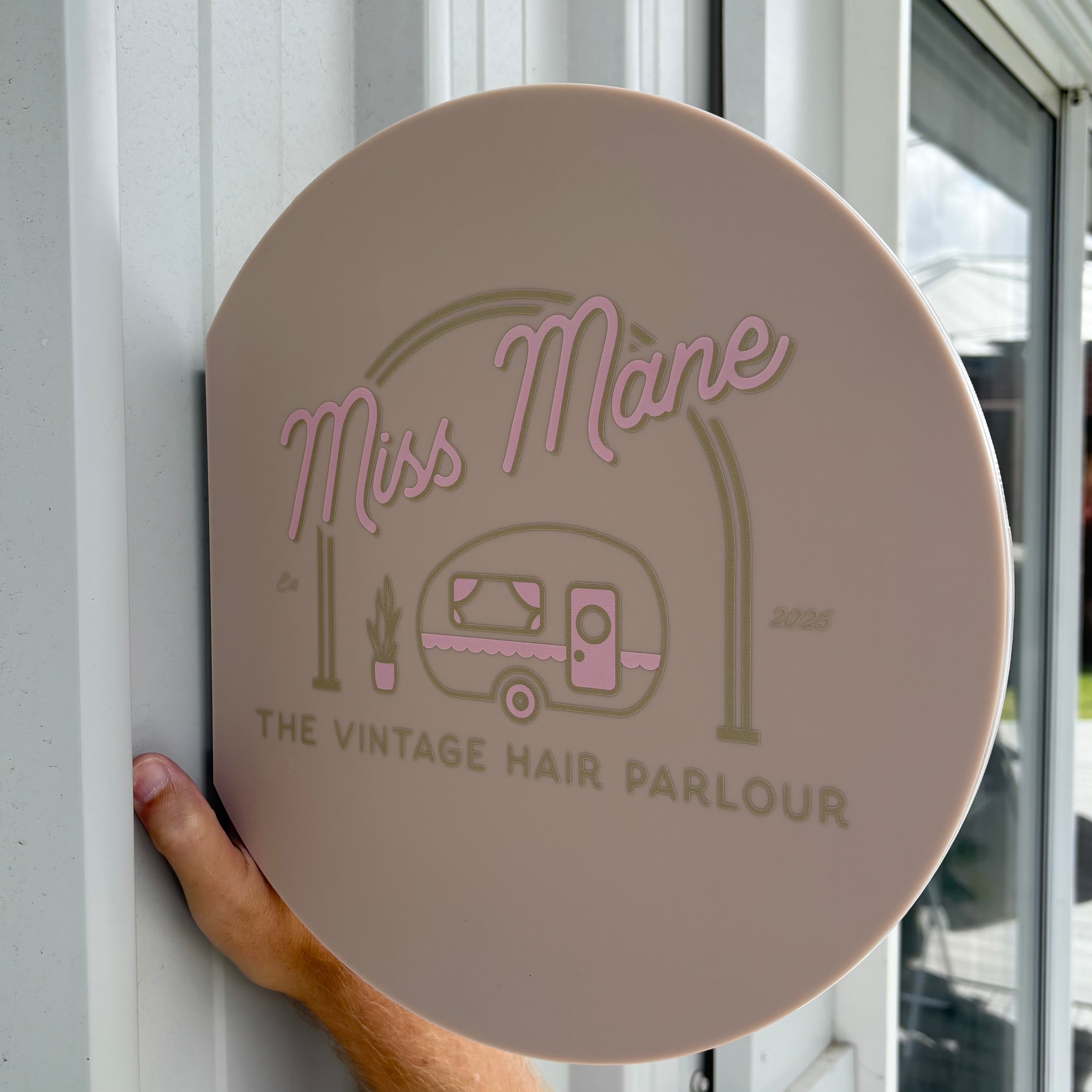 Round blush acrylic blade sign with raised pink and beige lettering, custom salon blade sign for hairdresser featuring Miss Mane vintage hair parlour branding, exterior business signage Australia