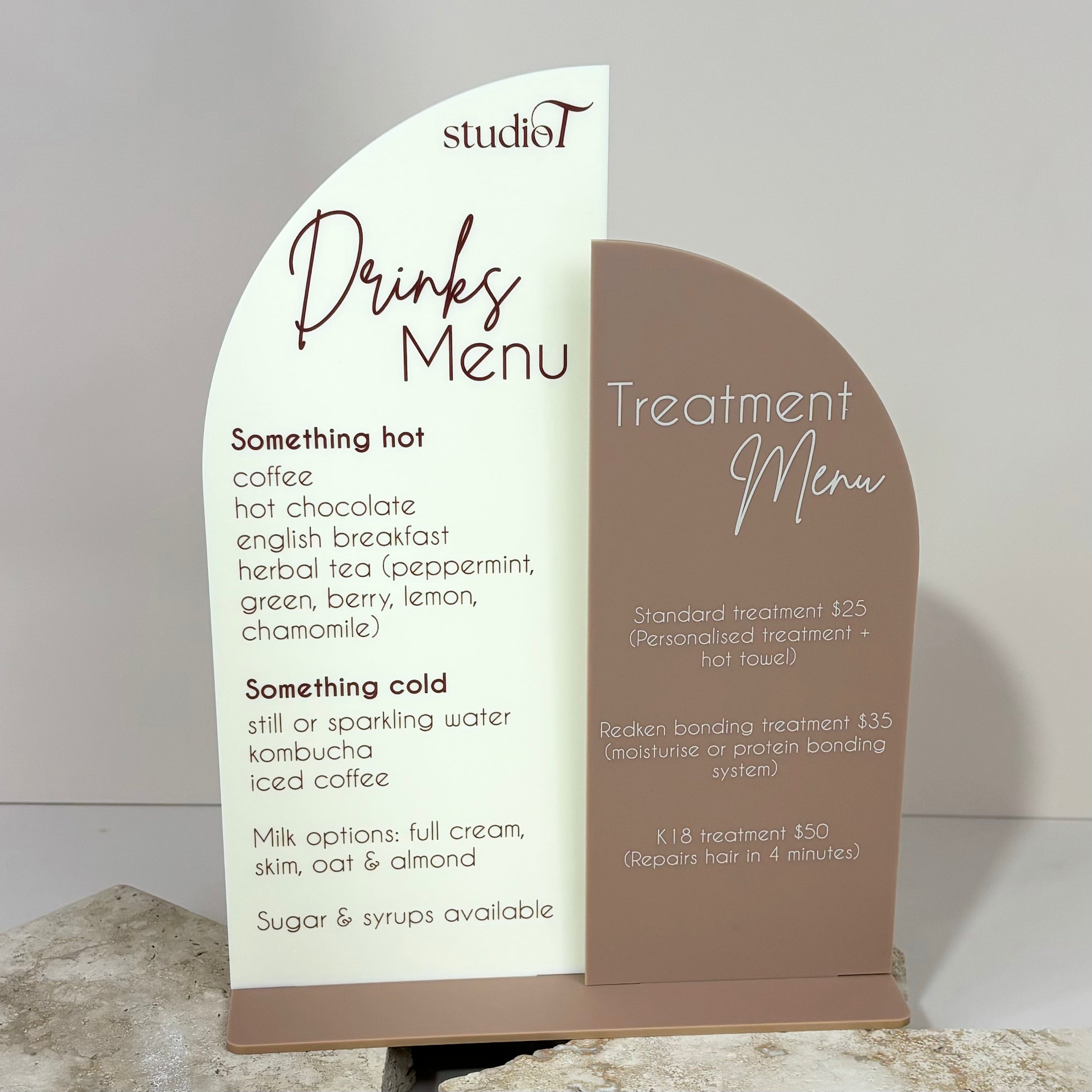 Two-tone curved acrylic sign showing bar drinks and salon treatments
