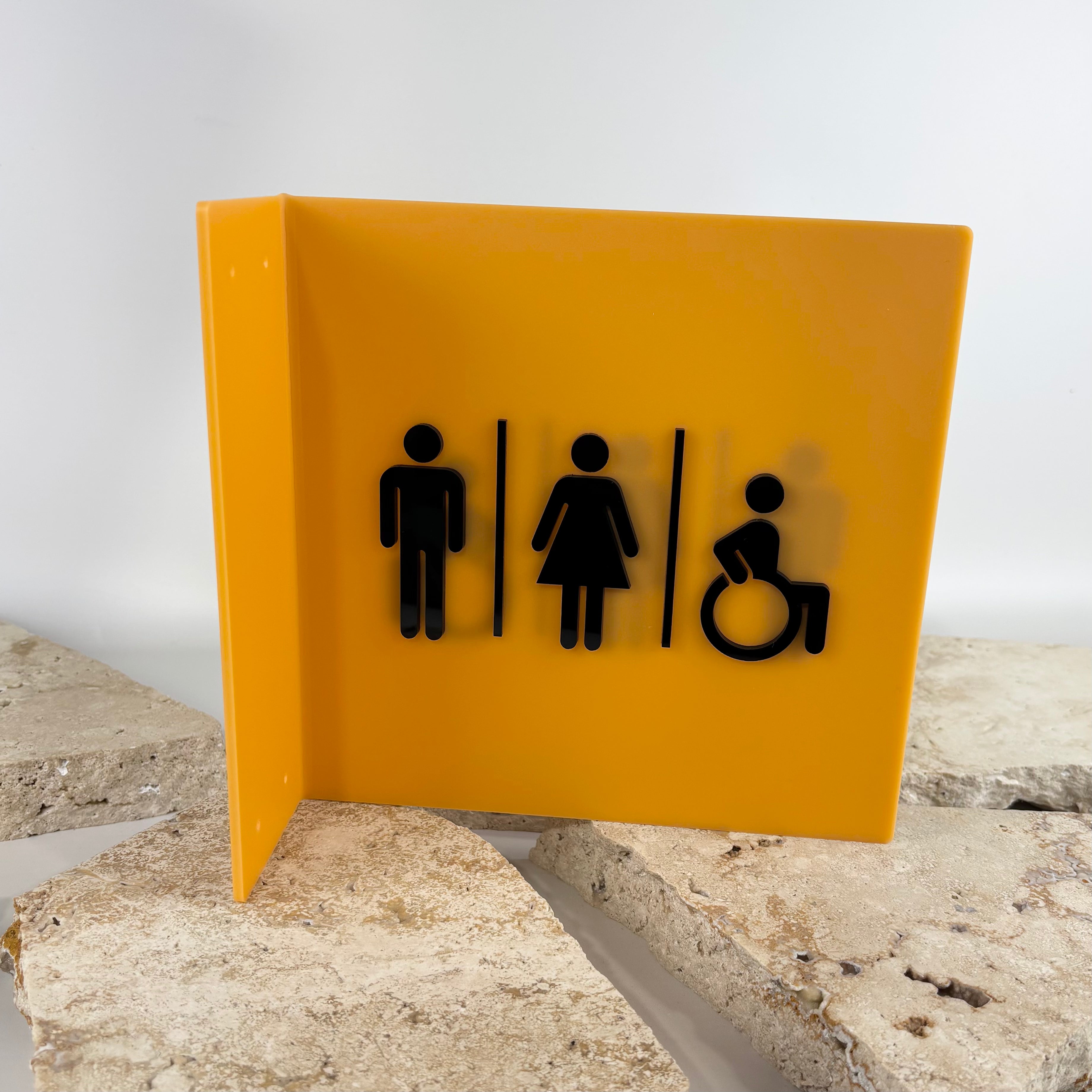 Custom acrylic bathroom sign with male, female and wheelchair accessible symbols for commercial businesses, cafes, salons and office spaces. Modern wall mounted toilet signage in yellow and black acrylic with raised 3D icons for accessible restroom wayfinding and business interiors in Australia.