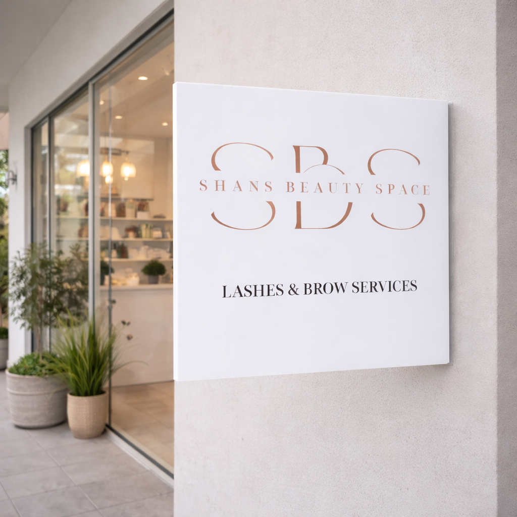 Custom acrylic business wall sign for lash and brow studio mounted outside beauty salon storefront, modern white business signage with rose gold lettering for beauty clinics, salons and small businesses.