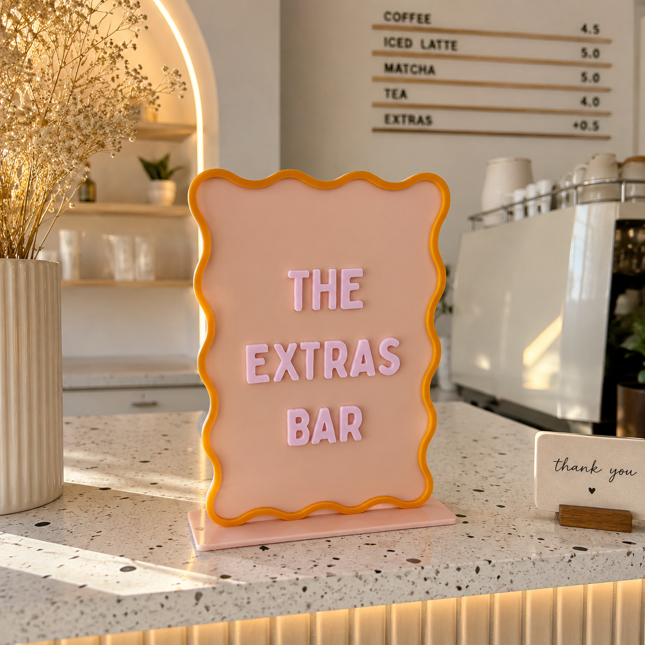 Pastel scallop display stand with interchangeable 3D letters on a modern café countertop, perfect for menus, pricing, promotions, retail displays, coffee shops, salons and market stalls.