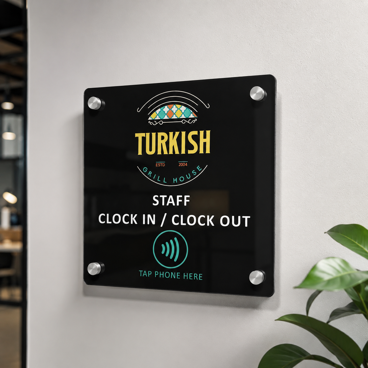 Custom NFC staff clock in station mounted on a workplace wall with silver standoffs, personalised business logo and tap phone clock in and out sign.