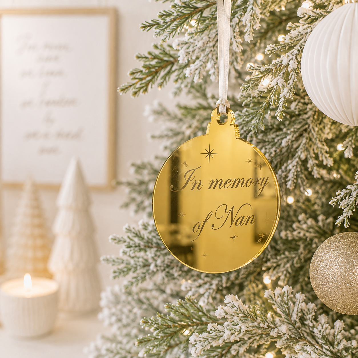 Personalised gold mirror acrylic memorial Christmas bauble engraved “In memory of Nan”, hanging on a modern frosted Christmas tree.