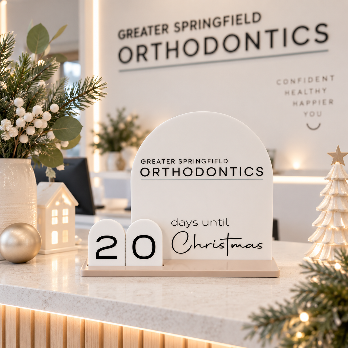 Custom business Christmas countdown sign with Greater Springfield Orthodontics logo, displayed on a modern dental reception desk.