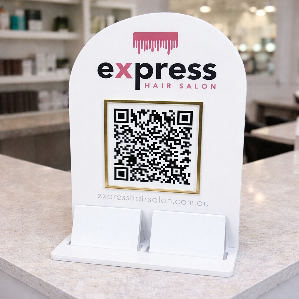 Custom white acrylic QR code sign on a hairdressing salon reception desk, featuring Express Hair Salon branding, scannable QR code, website URL and dual business card holders