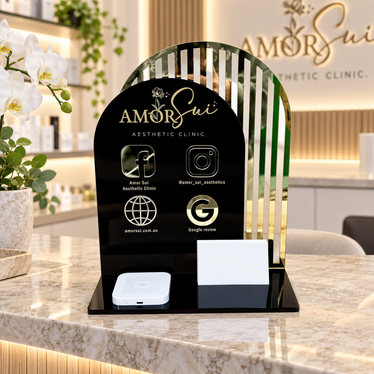 Custom acrylic NFC business station for a non-surgical aesthetic clinic, featuring social media, website and Google review tap-to-connect icons, Square Reader and business card holder on a clinic reception counter.