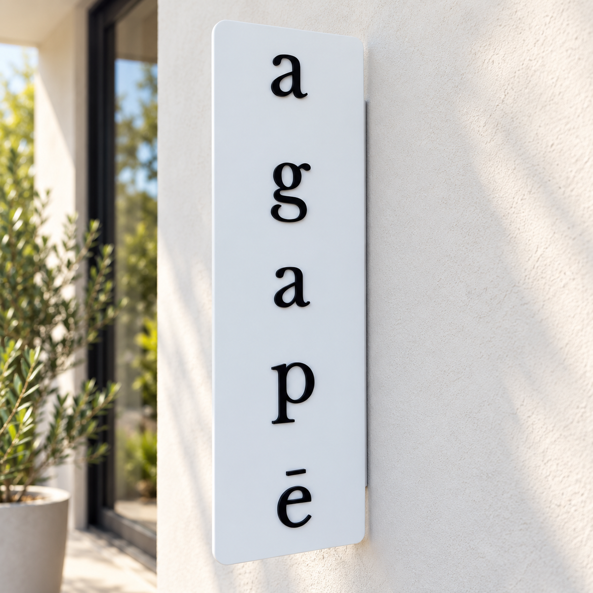 Custom vertical white acrylic business sign with raised black 3D lettering, mounted on a modern textured wall outside a beauty salon.