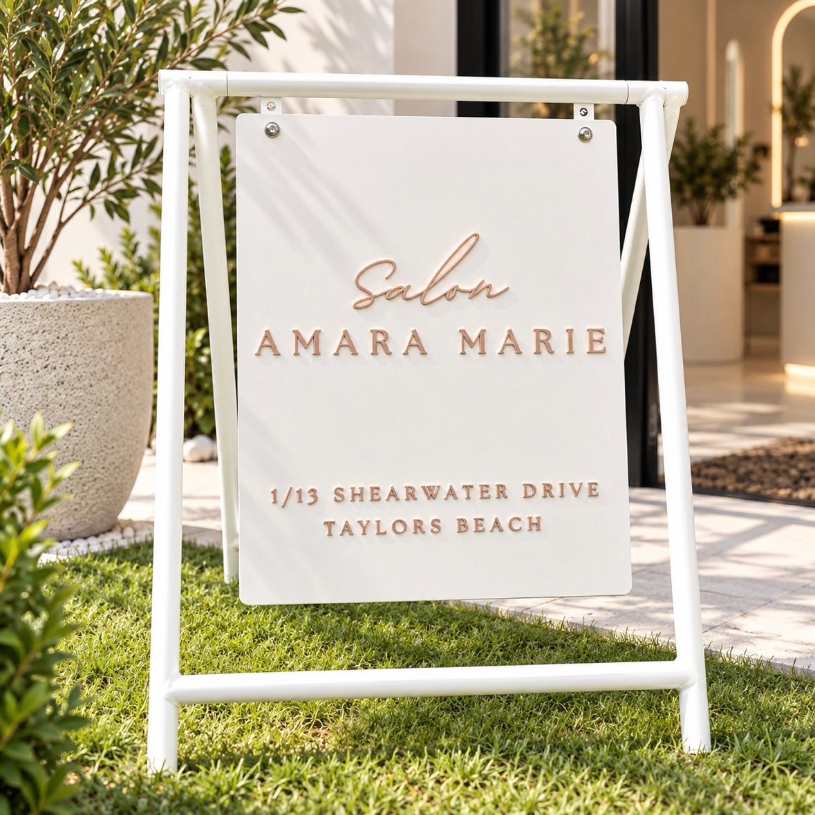 Custom white outdoor A-frame salon sign with raised 3D acrylic lettering for Salon Amara Marie, displayed outside a modern beauty salon entrance.