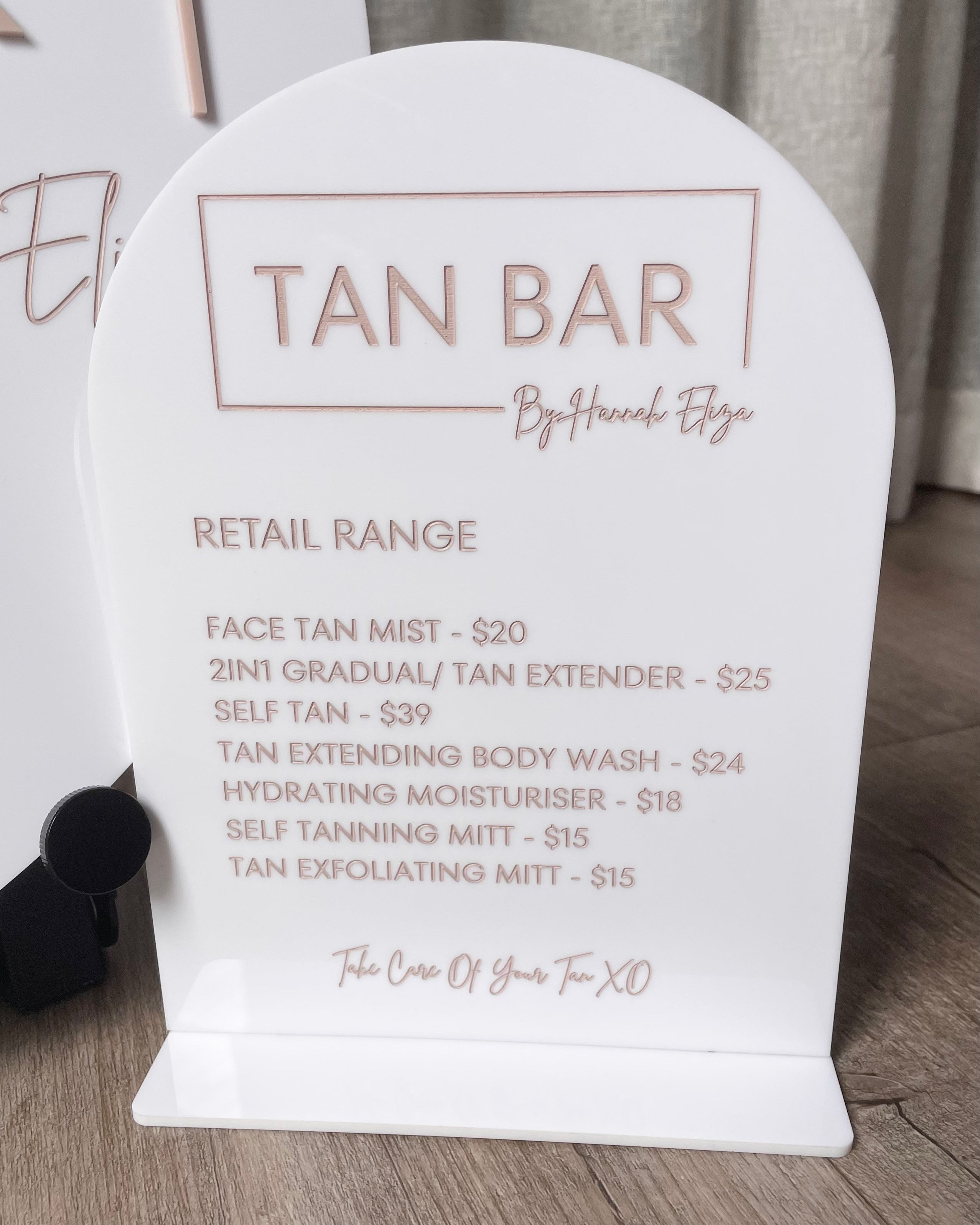 Retail price list on arched acrylic sign for tanning studio with custom logo
