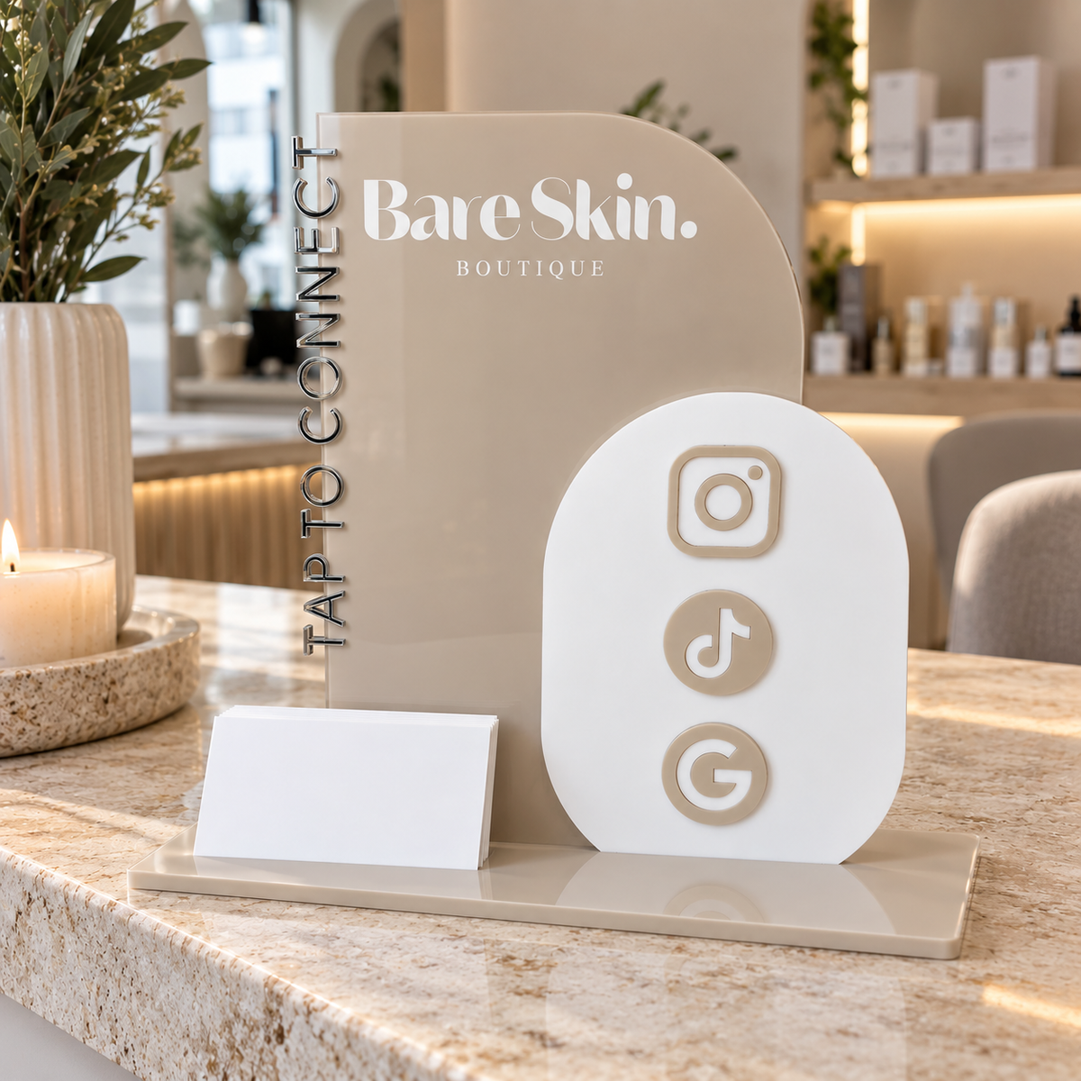 Custom acrylic NFC social media business station with Instagram, TikTok and Google tap-to-connect icons and business card holder, displayed on a modern skin clinic reception counter.