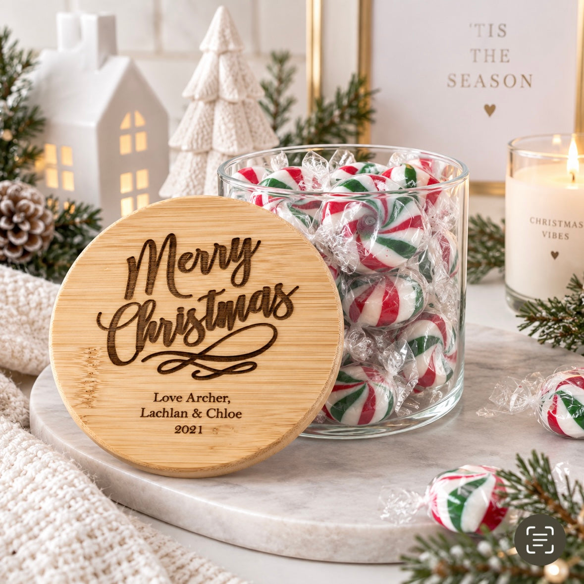 Personalised Christmas lolly jar with engraved bamboo lid, displayed in a light modern Christmas setting with festive peppermint sweets and decorations.