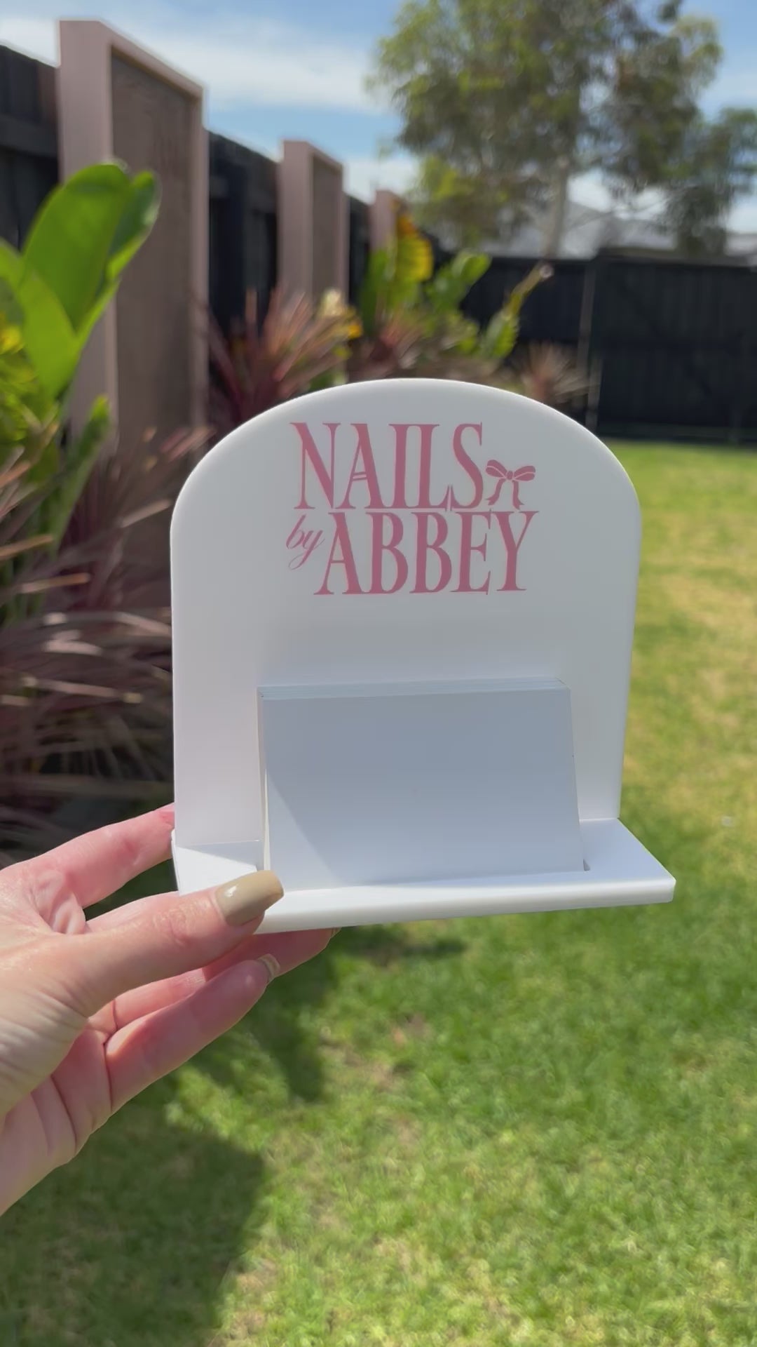 White business card stand with custom branding for nail salon. Video 