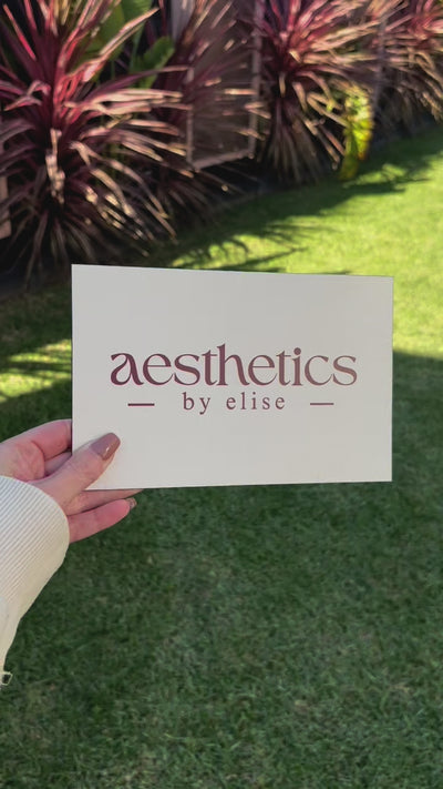 Aesthetics by Elise aluminium sign in natural light, handheld custom metal sign with business logo, perfect for beauty clinics.