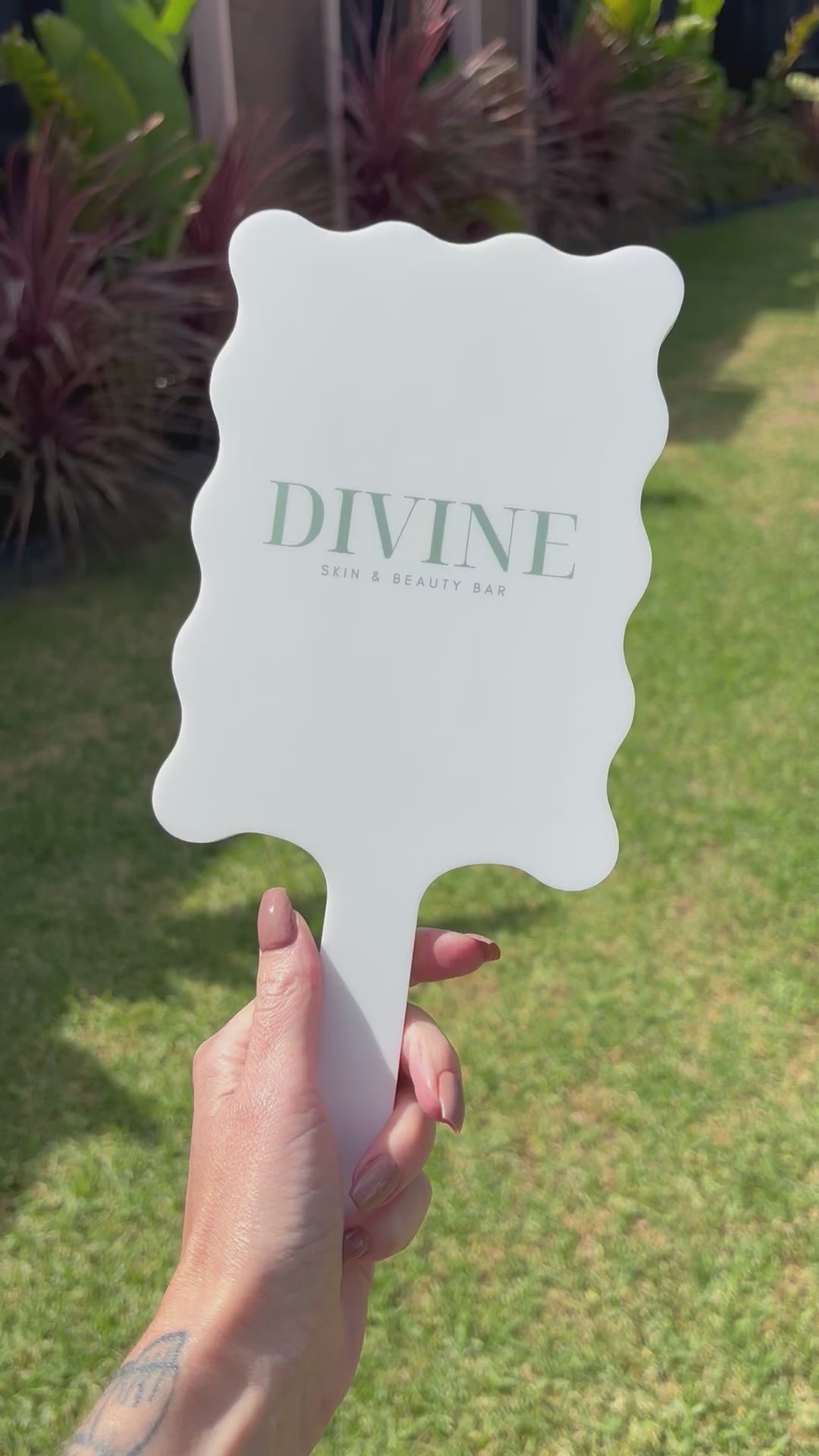 Video White wavy salon mirror with Divine branding shown outdoors