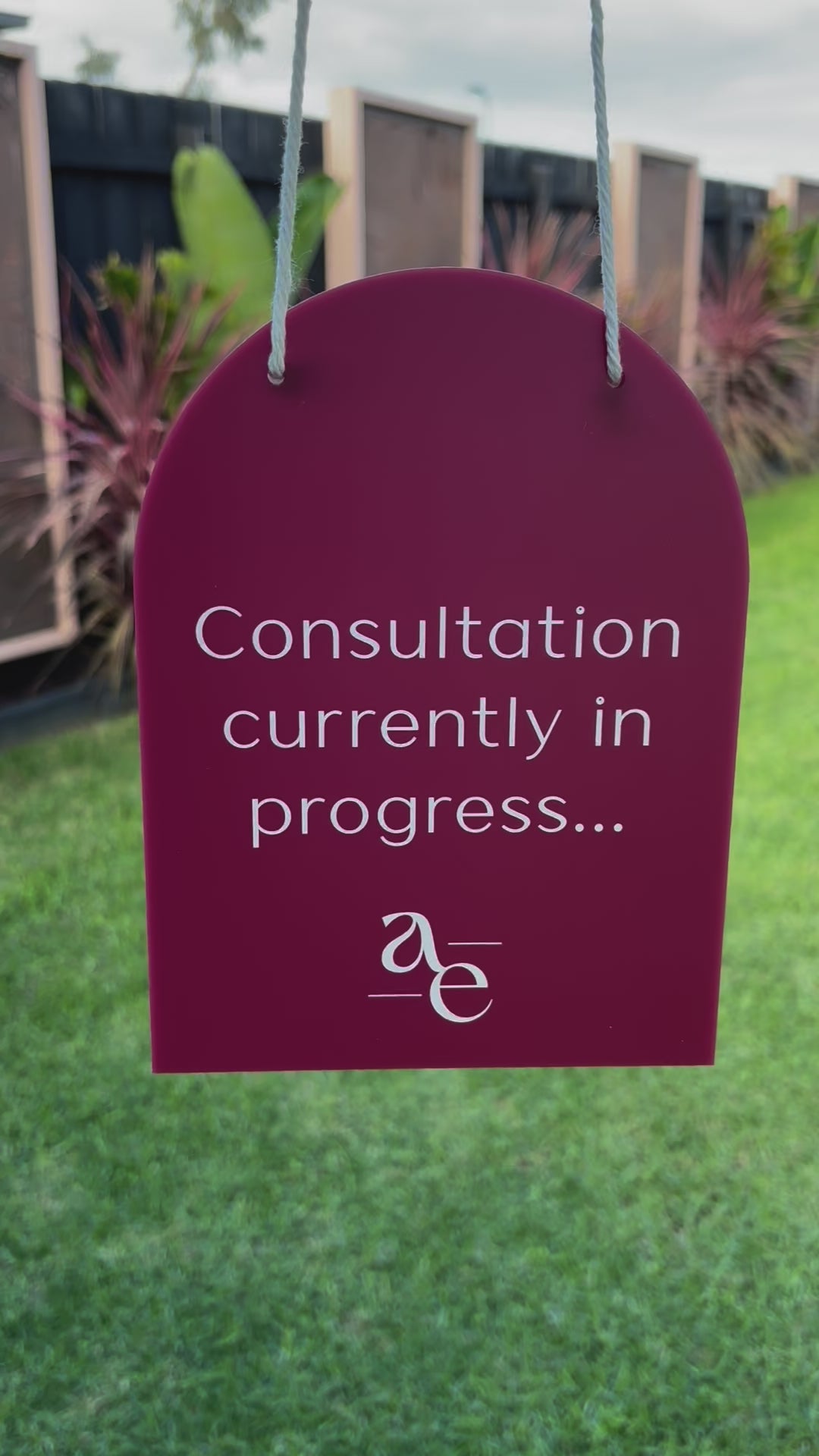 Purple mini arched hanging sign with custom message “Consultation currently in progress…” displayed outdoors. Video 