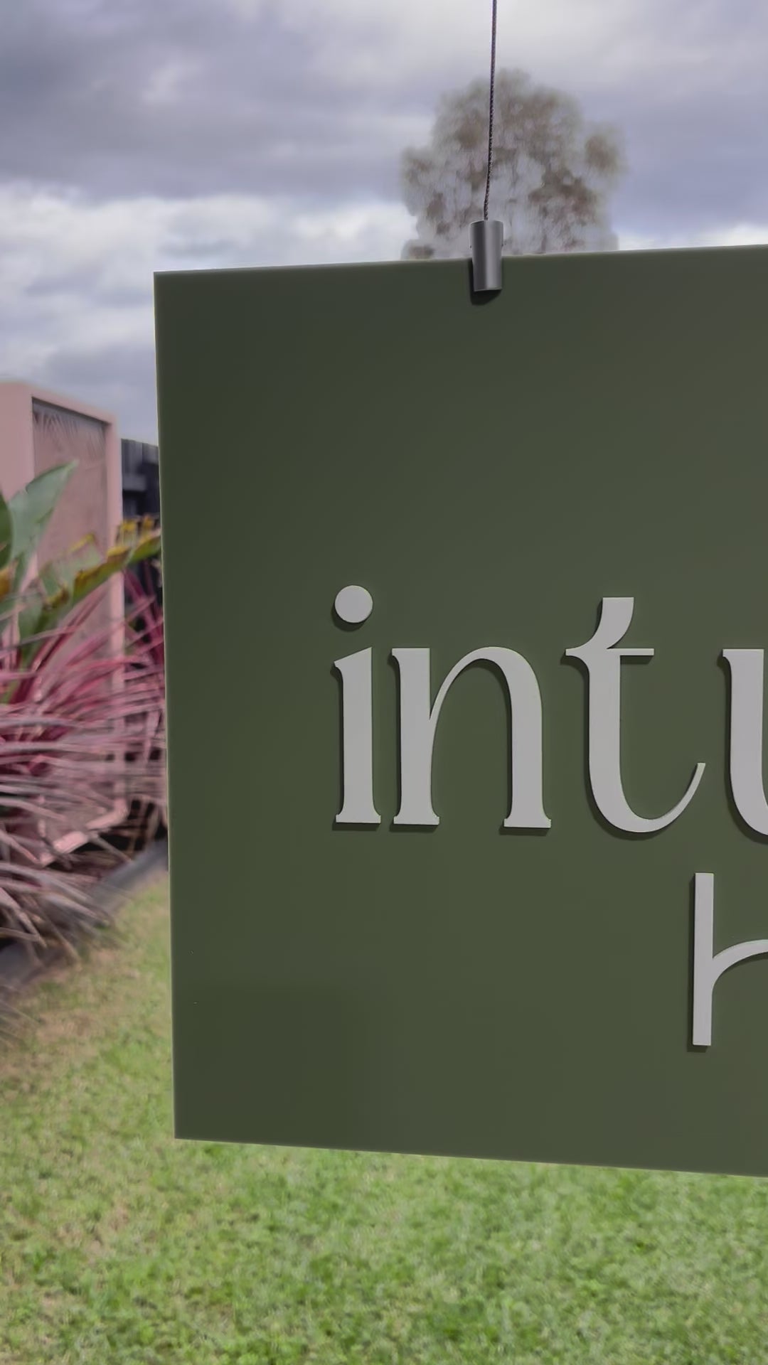 Close up of custom hanging sign with Intuitive Hair branding. Video 