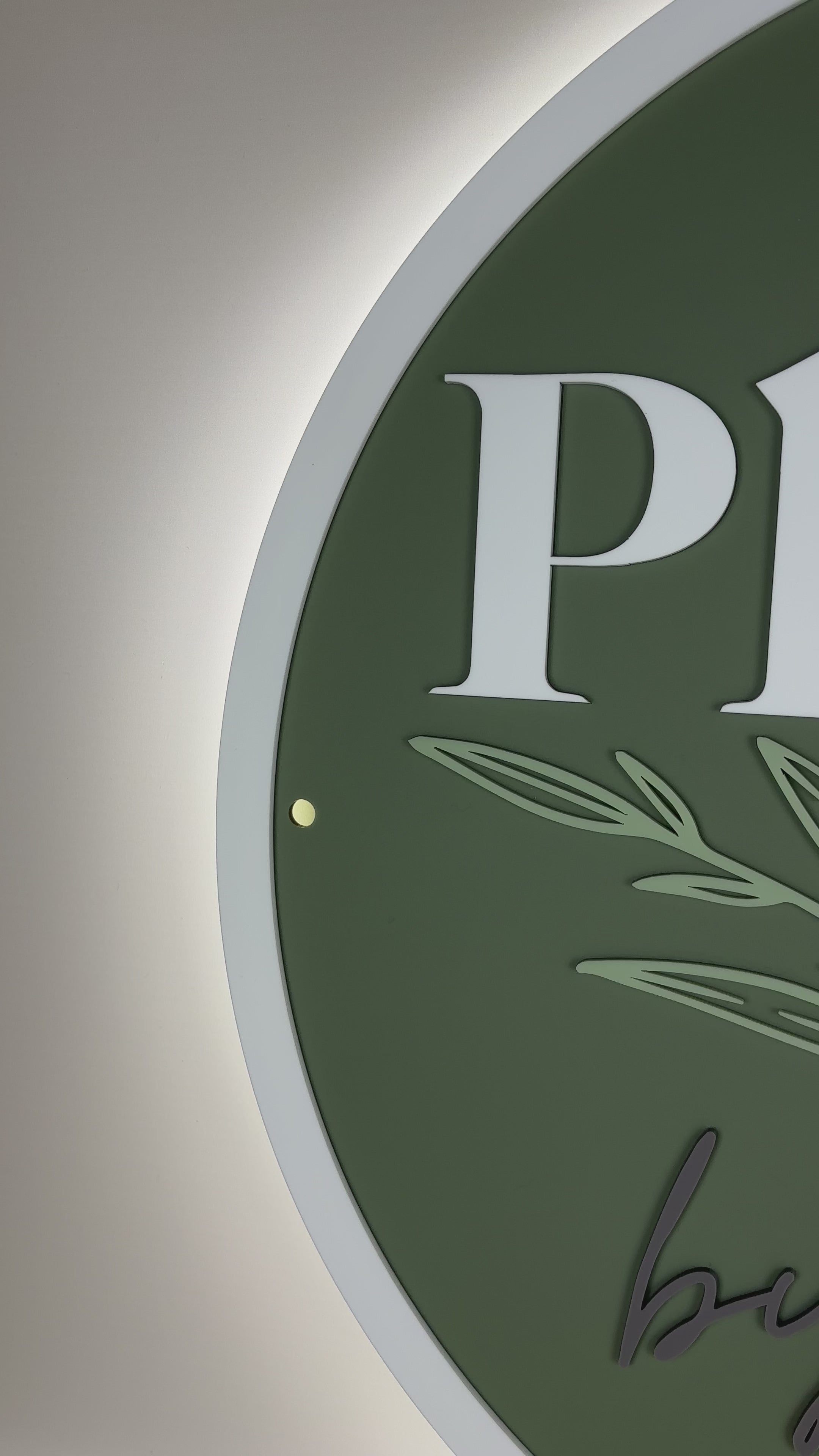 Green round LED backlit business sign with white engraved logo – personalised branding display