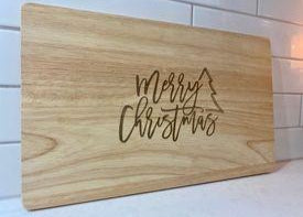 Wooden personalised Christmas chopping board engraved with tree design and Merry Christmas message