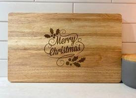 Engraved wooden chopping board with Merry Christmas and holly leaves design ideal for festive entertaining