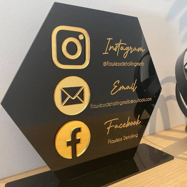Black hexagon QR code sign with gold social media icons for Instagram, email and Facebook