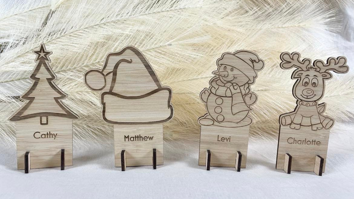 Wooden Christmas place cards engraved with reindeer and tree designs personalised for table decorations