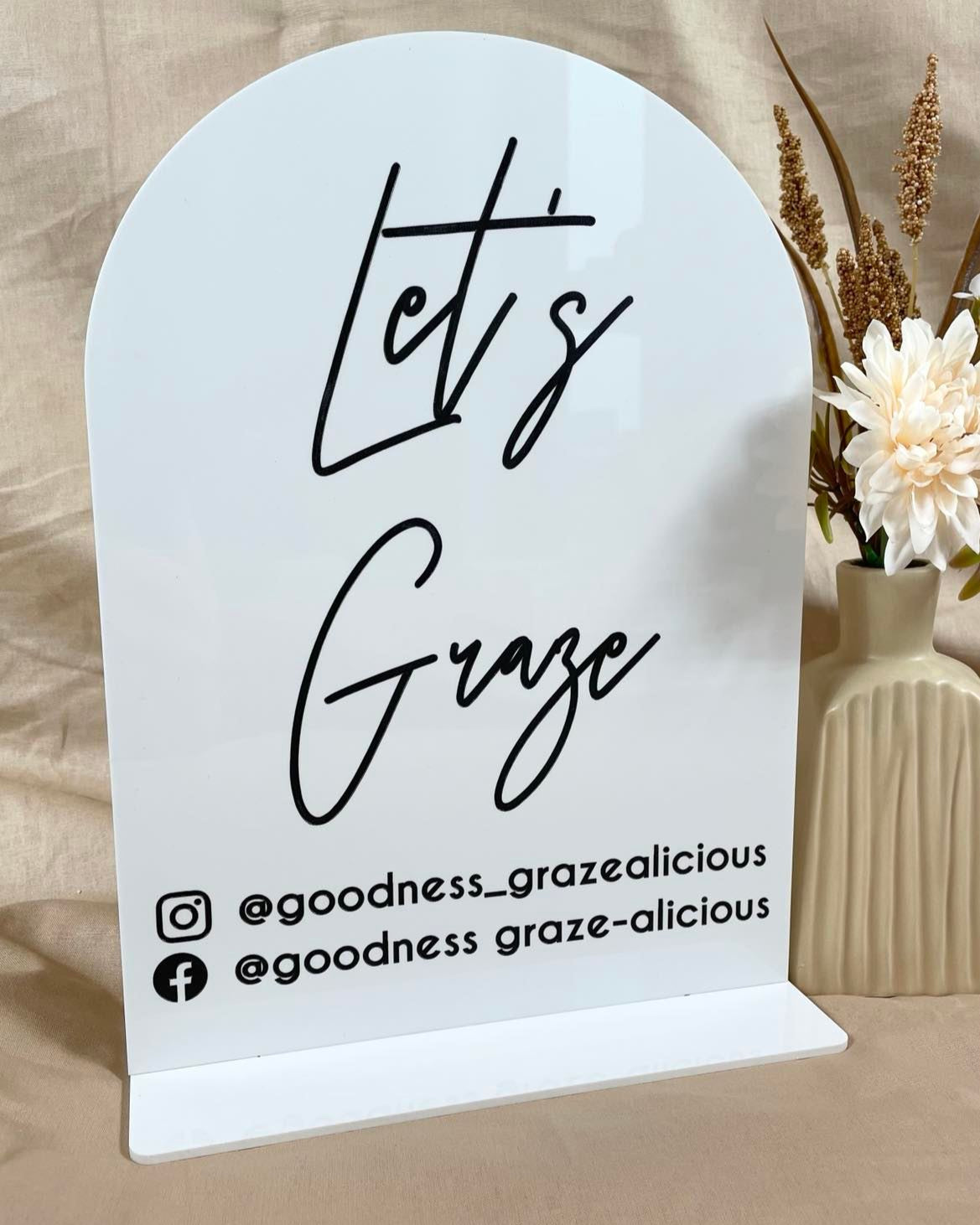 White branded info stand with Instagram handle and logo