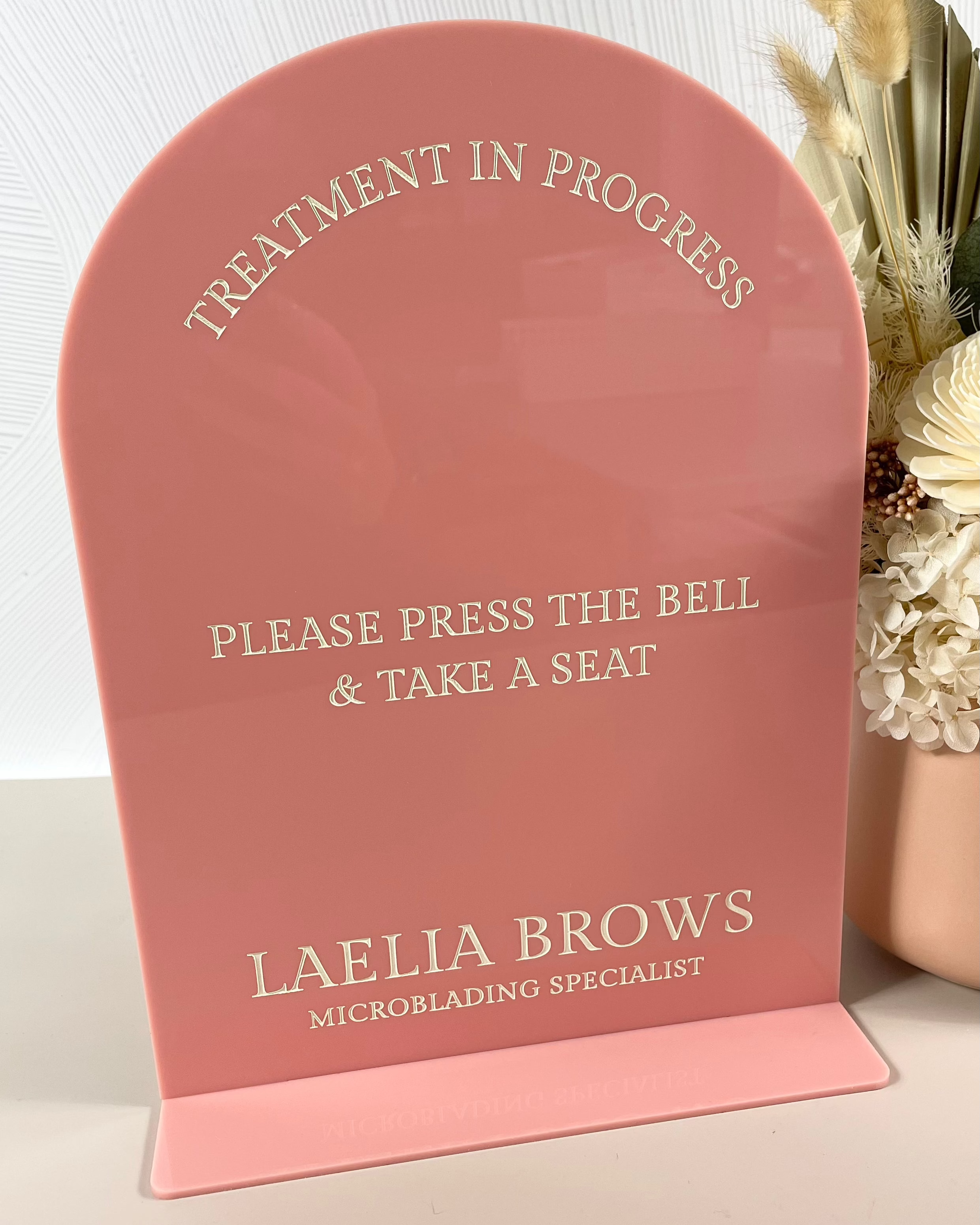 Pink salon sign with treatment in progress message