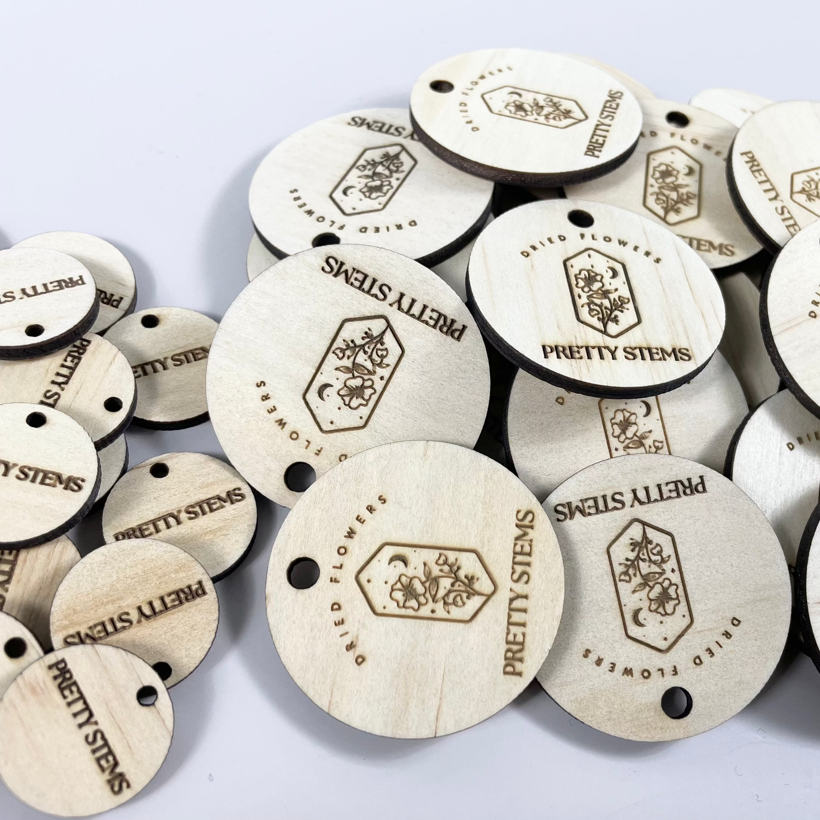 Engraved timber tags with small icons and text for business branding